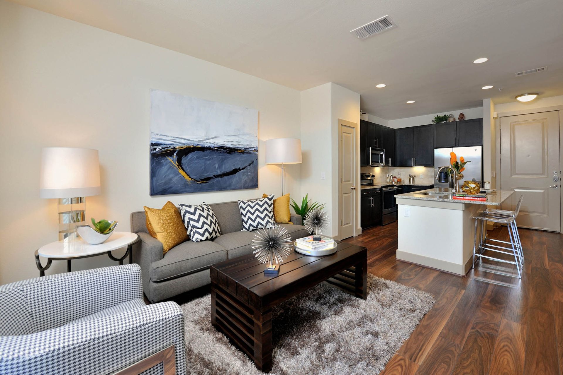 Open-concept living room with a gray sofa, coffee table, and kitchen island.