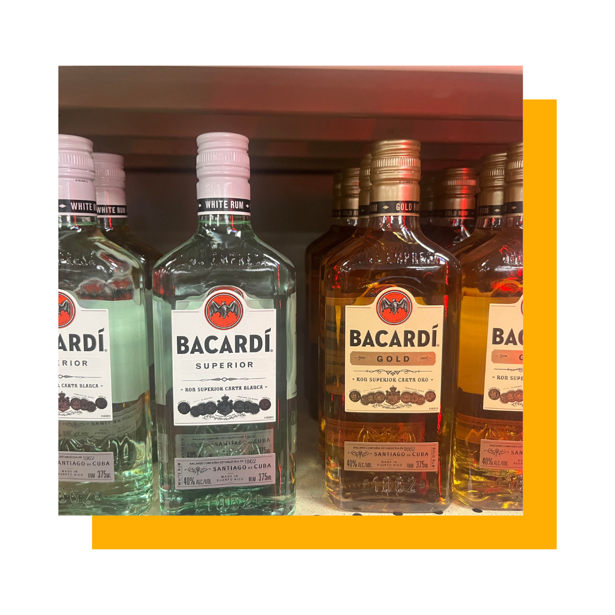 Bottles of Bacardi flavored rum on a shelf, various colors and flavors.