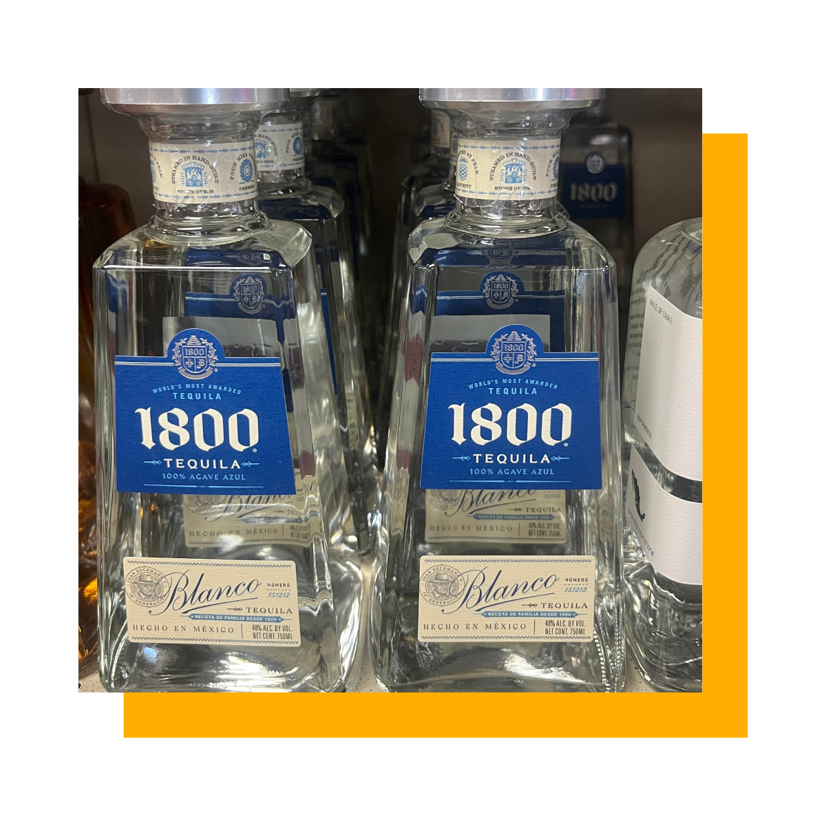 Two bottles of 1800 Blanco tequila on a shelf, with a blue and white label.