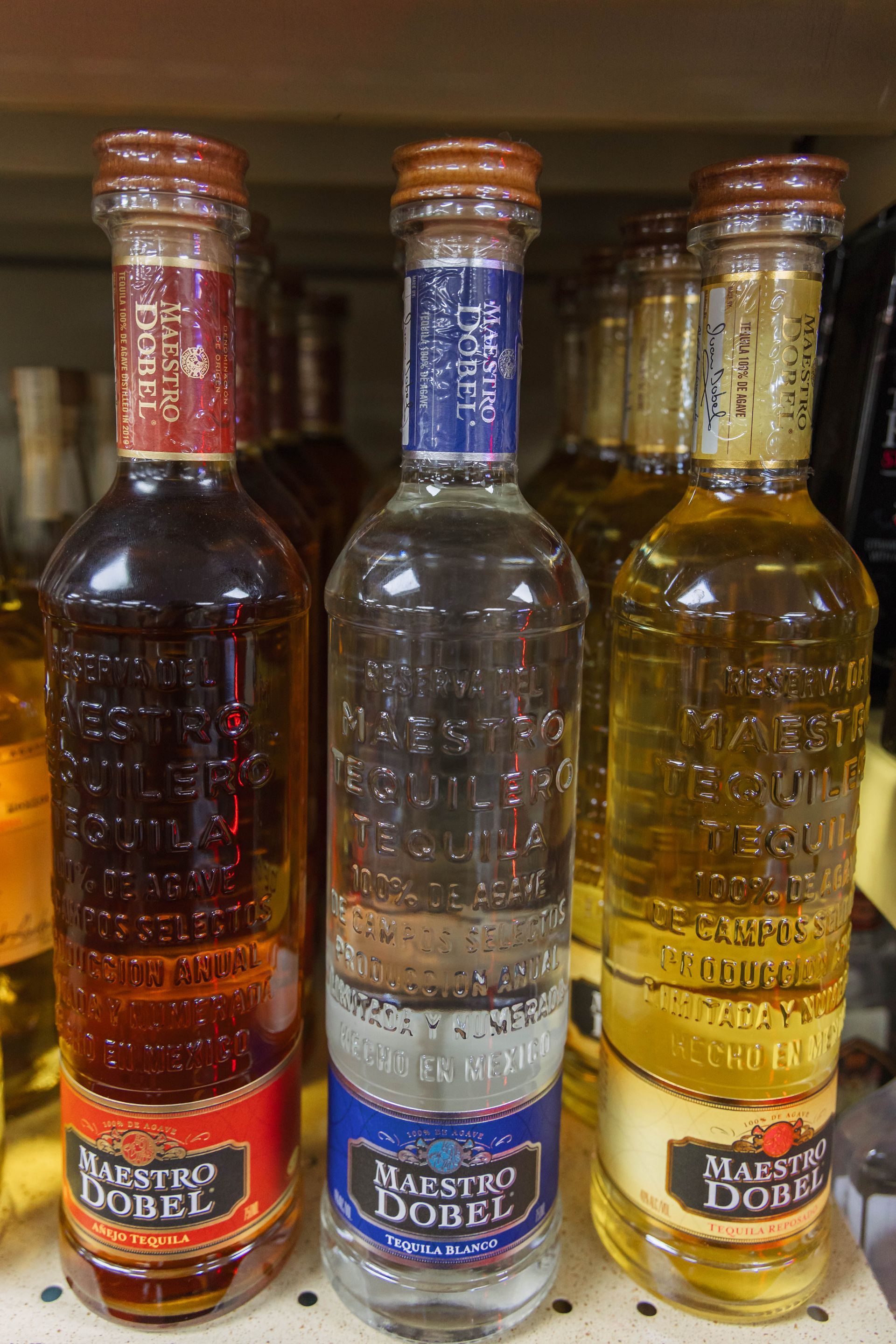 Three Maestro Dobel tequila bottles with different colored labels.
