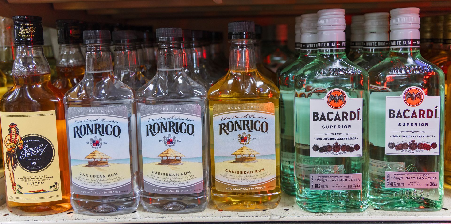 Bottles of liquor on a shelf, including Ronrico and Bacardi brands.
