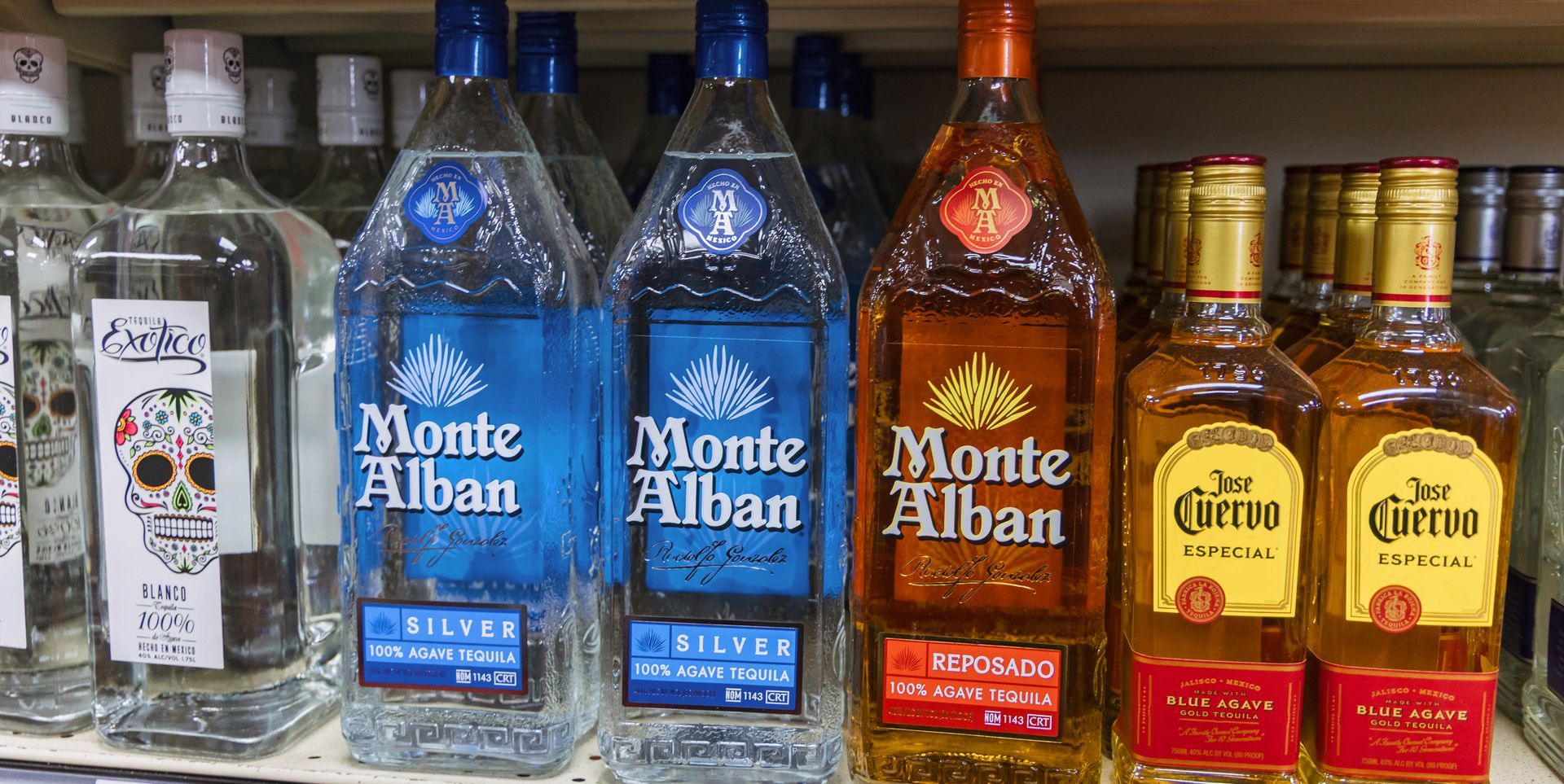 Bottles of tequila on a shelf, including Monte Alban and Don Cuervo brands.