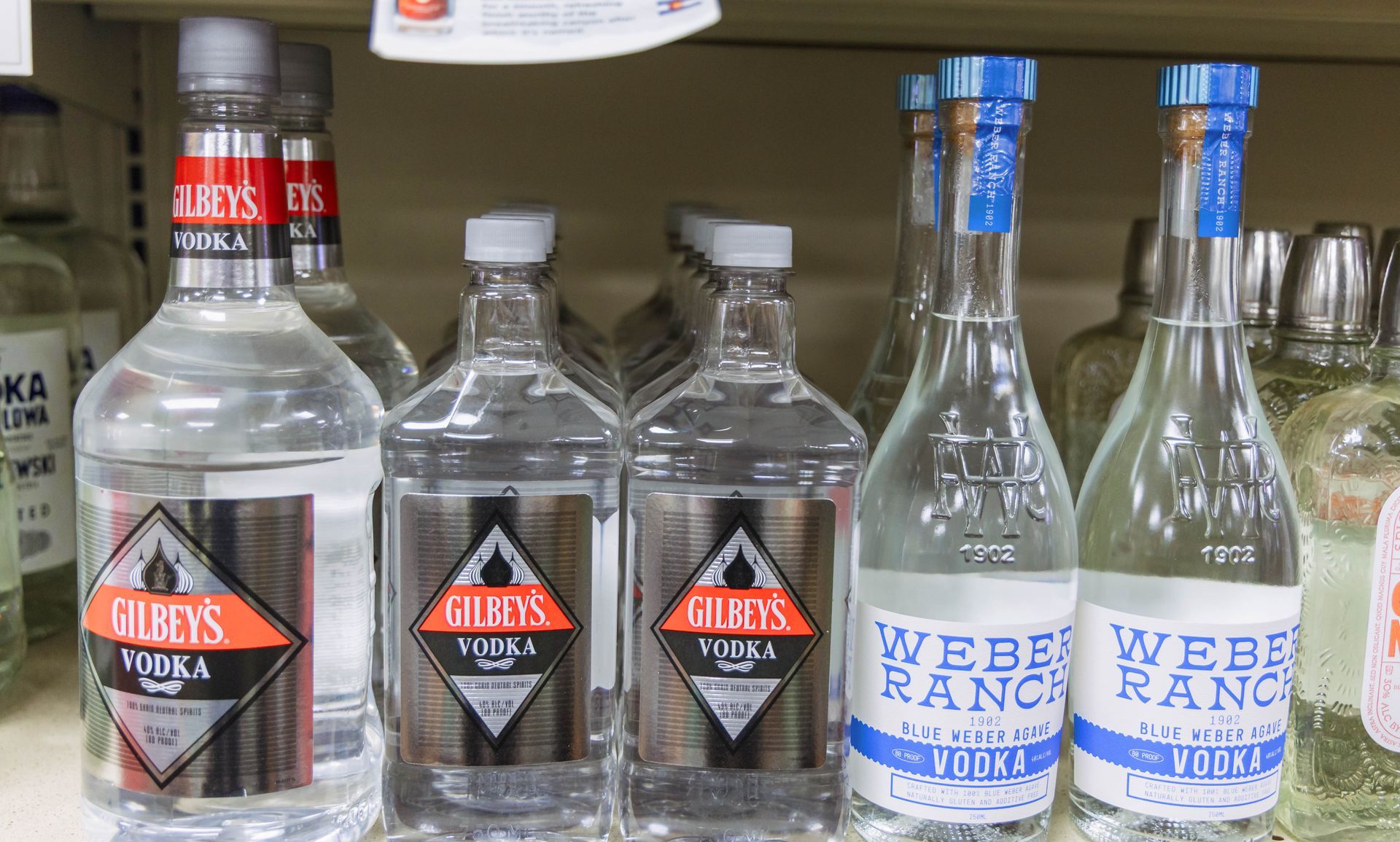Bottles of vodka, including Gilbey's and Weber Ranch, on a store shelf.