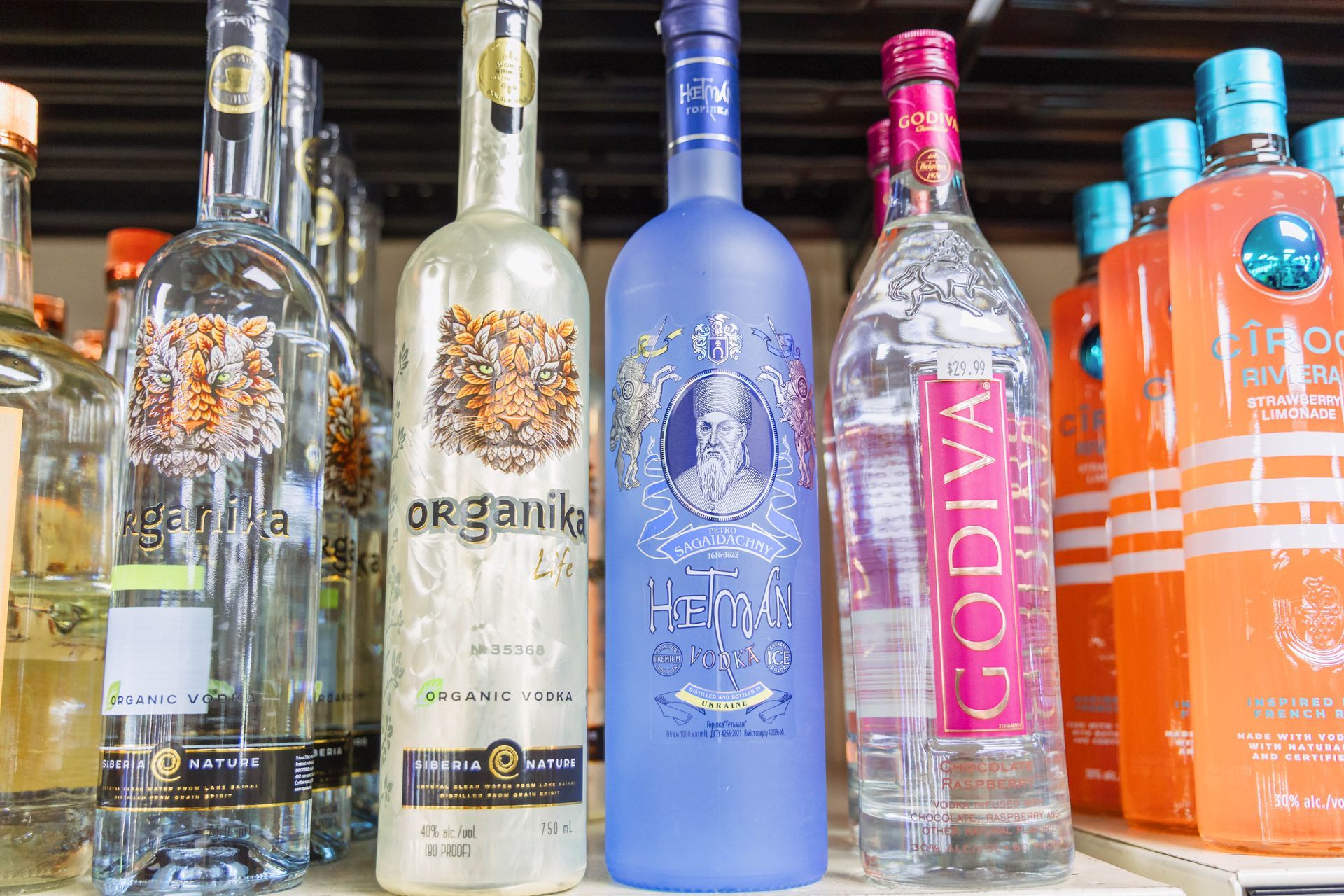 Bottles of liquor on a shelf, including a blue bottle with a portrait and bottles with decorative labels.
