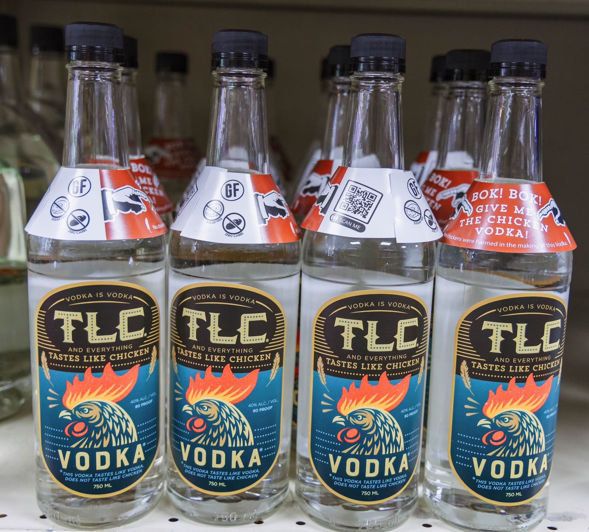 Bottles of TLC Vodka with a rooster logo on a shelf.