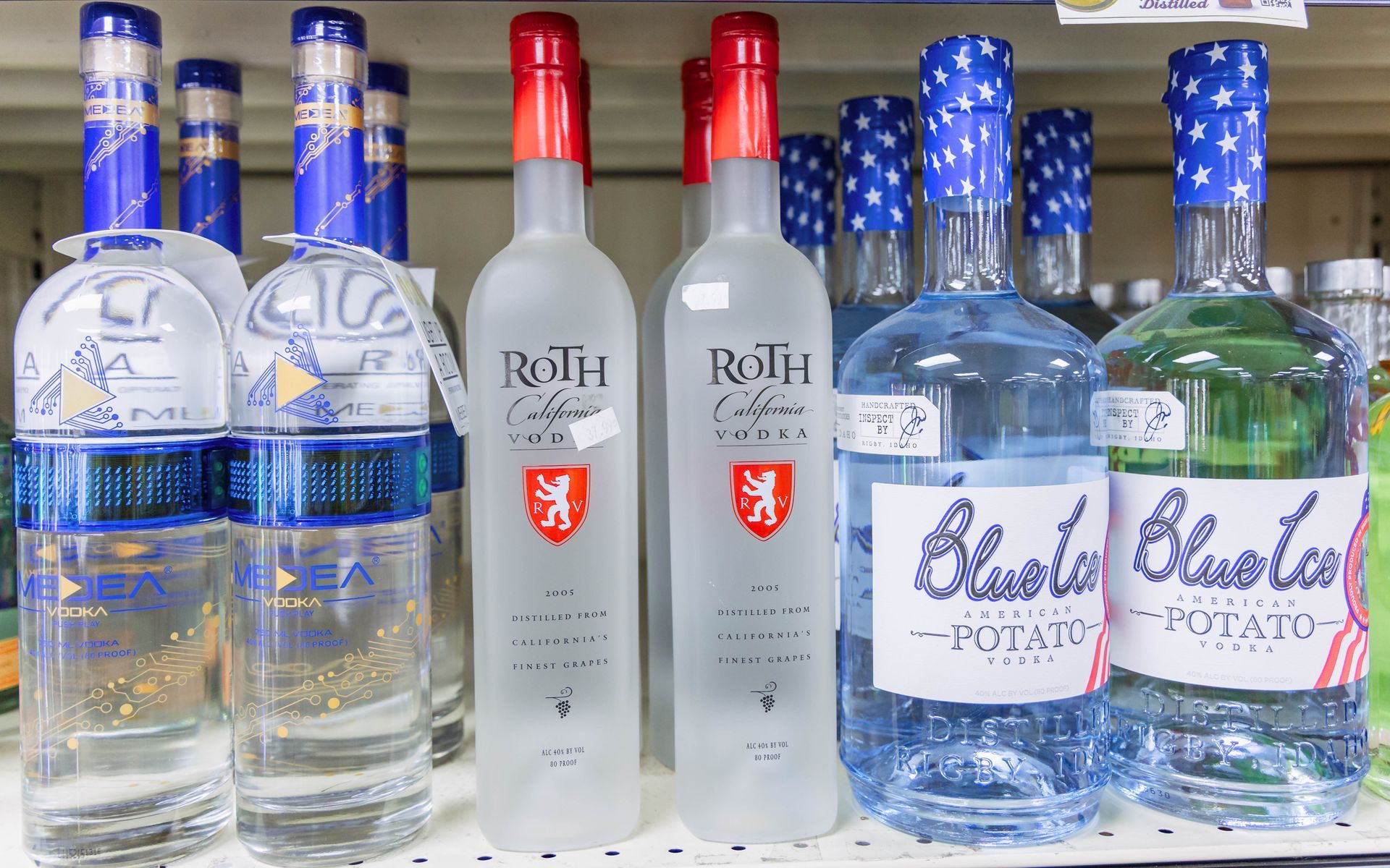 Bottles of liquor on a shelf: Roth vodka (red cap), Blue Lake potato vodka (blue label/cap).