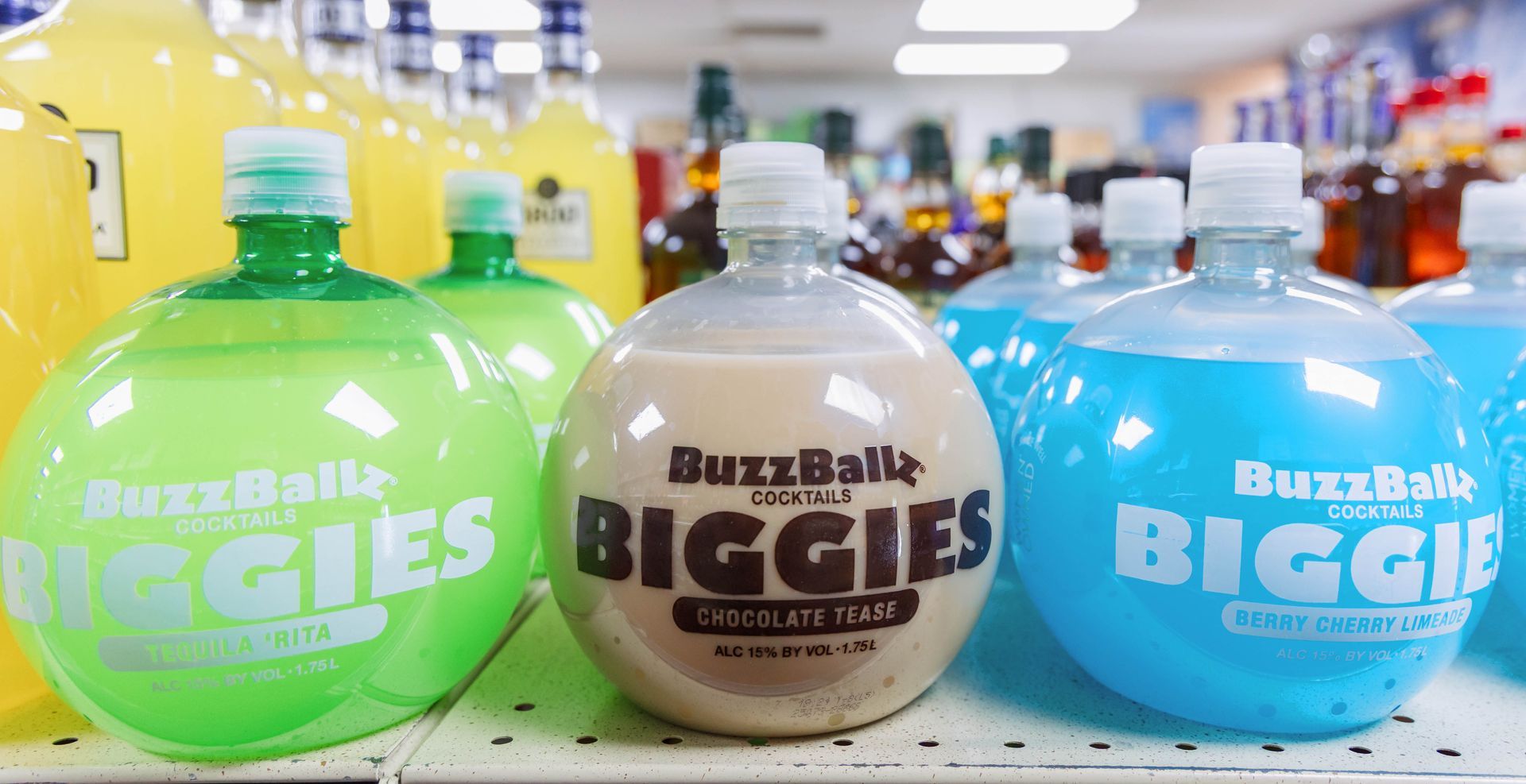 BuzzBallz Biggies alcoholic beverages in assorted colors on a shelf.