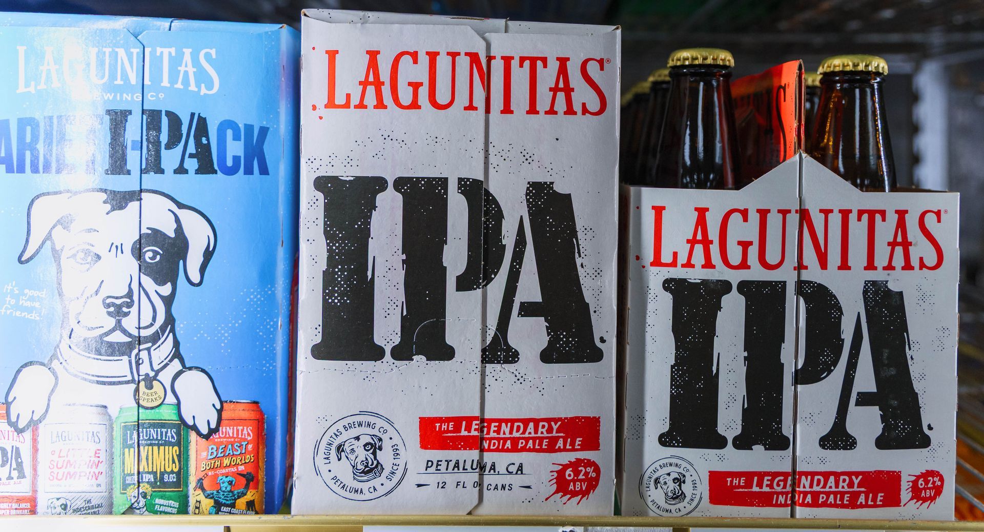 Three Lagunitas IPA beer boxes on a shelf; blue and white colors.