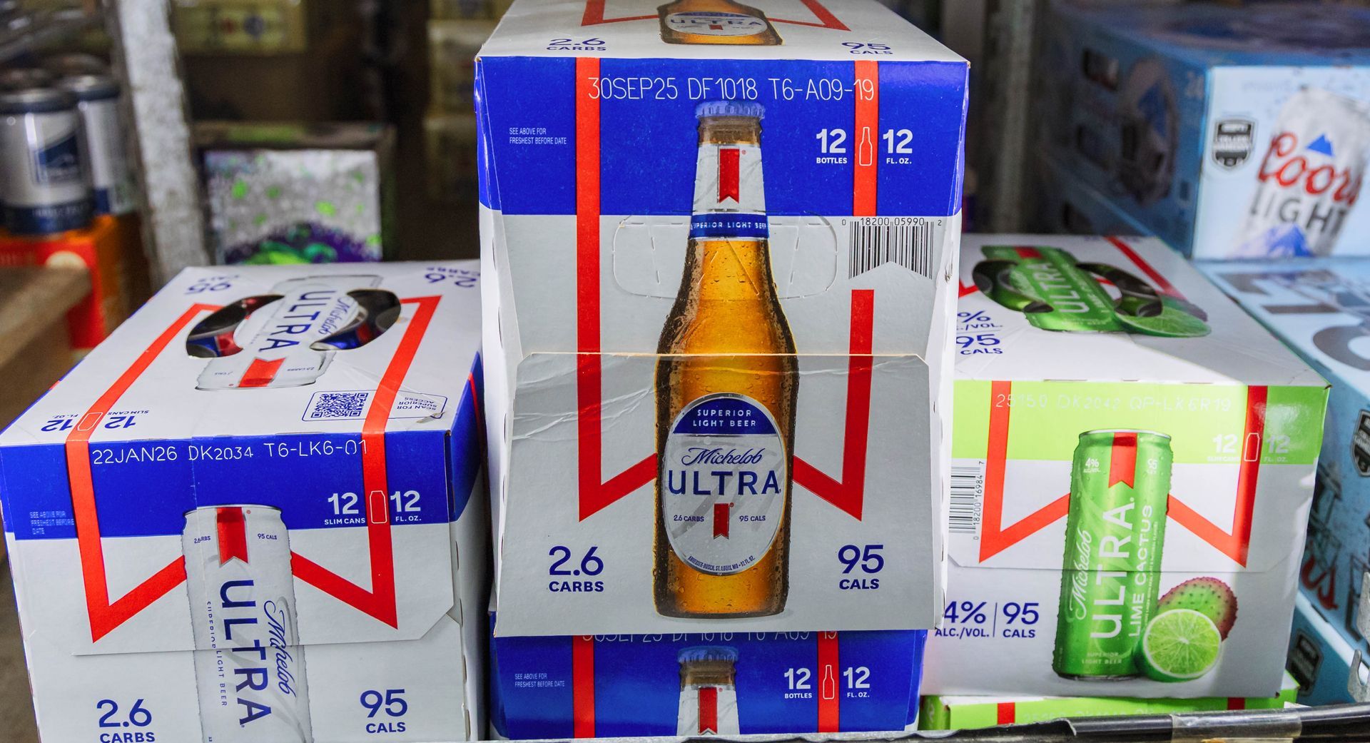 Cases of Miller Lite Ultra and a lime-flavored beverage in a refrigerated display.
