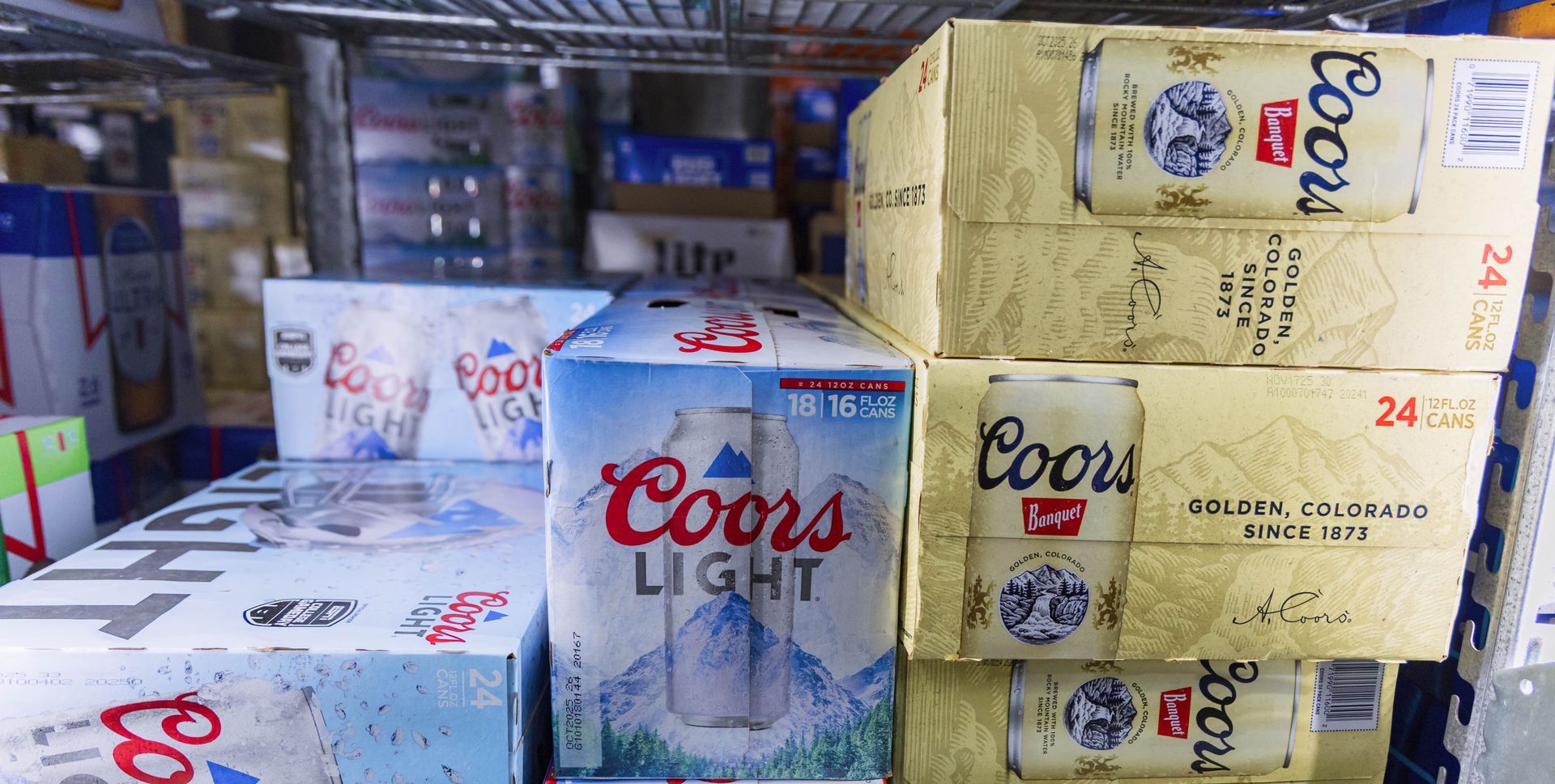 Cases of Coors Light stacked on shelves at a store.