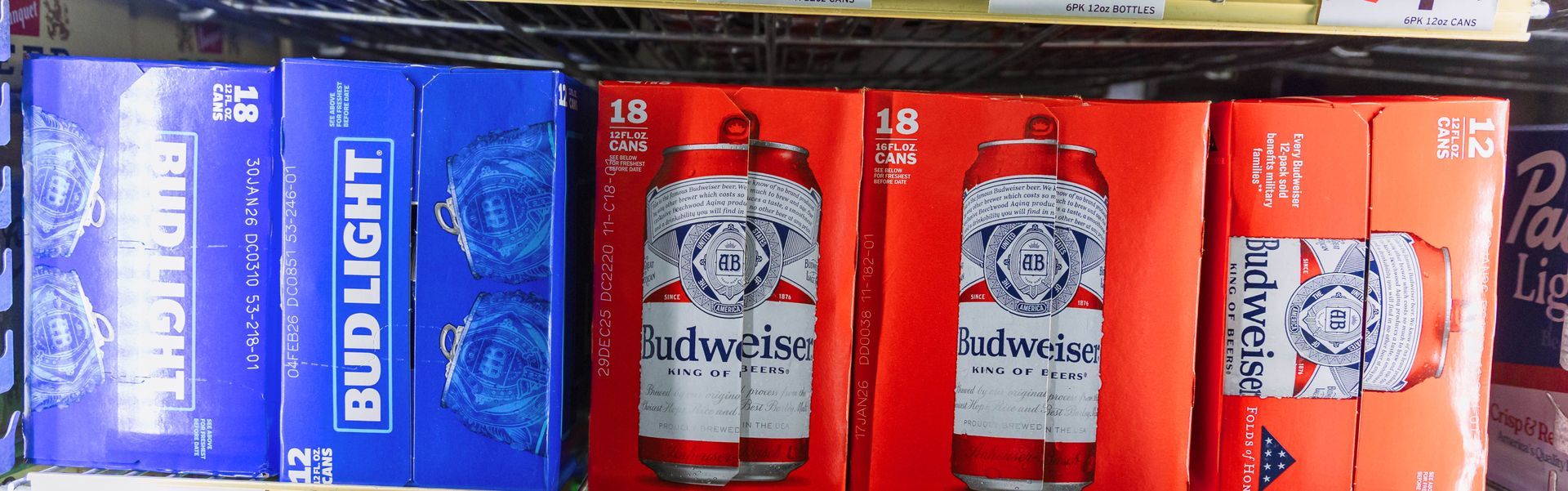 Beer cases in a store: Bud Light (blue) and Budweiser (red/orange).