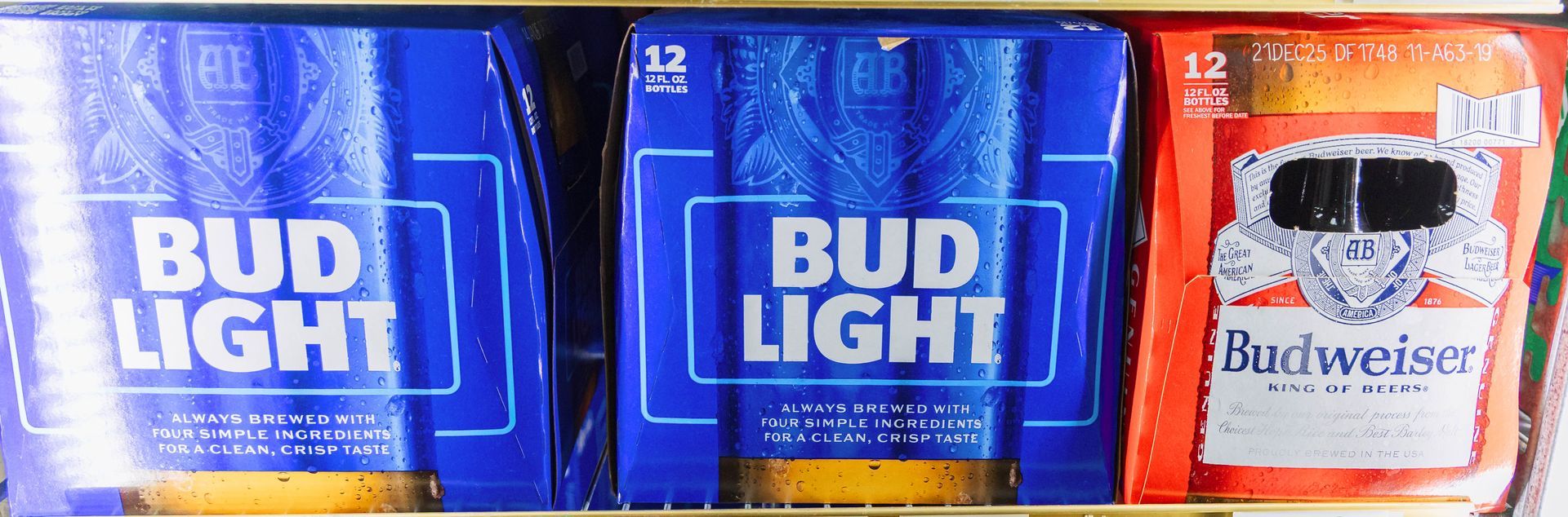 Bud Light and Budweiser beer packages stacked in a cooler.