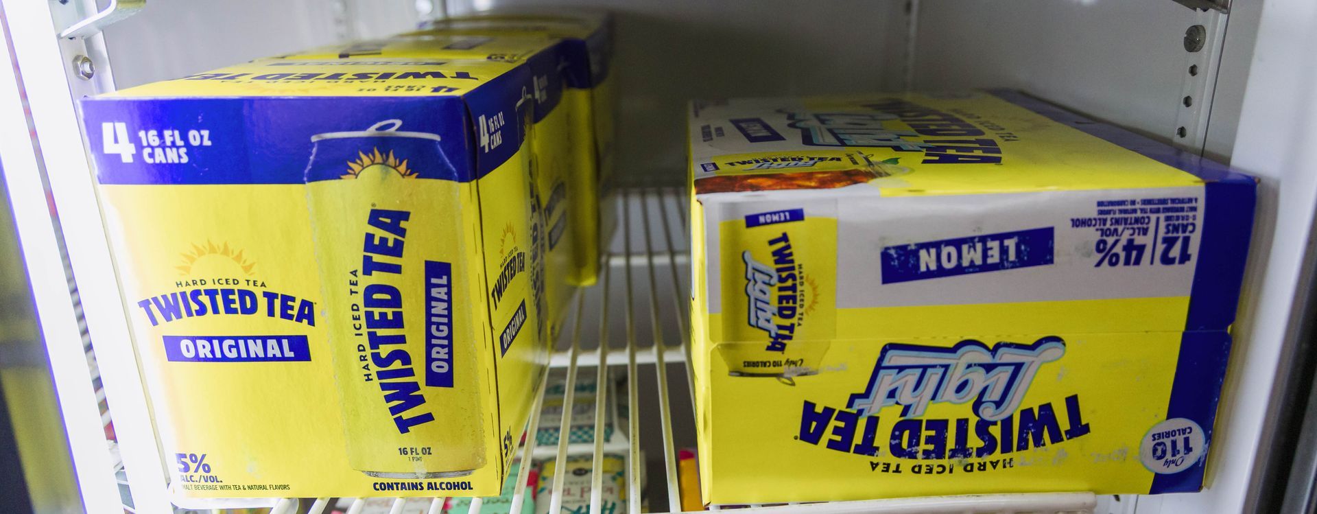 Boxes of Twisted Tea are stacked in a refrigerator; one is