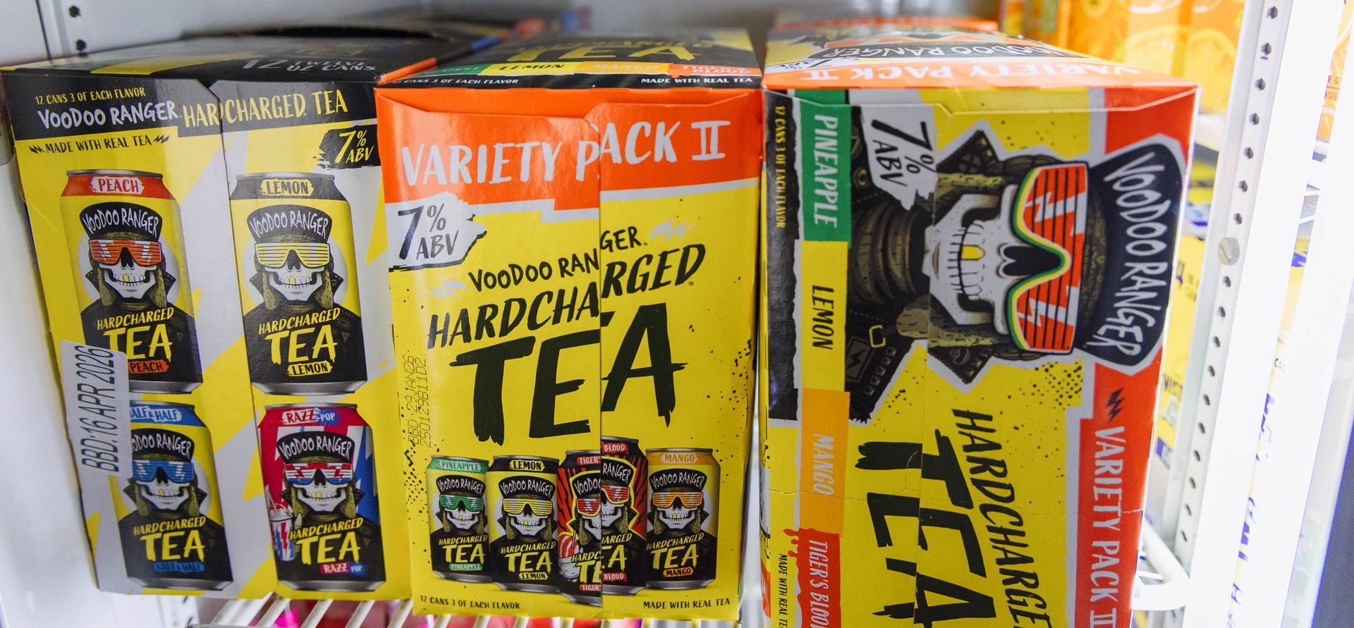 Boxes of Hard Charged Tea in a cooler, featuring a skull with sunglasses, yellow, and red packaging.