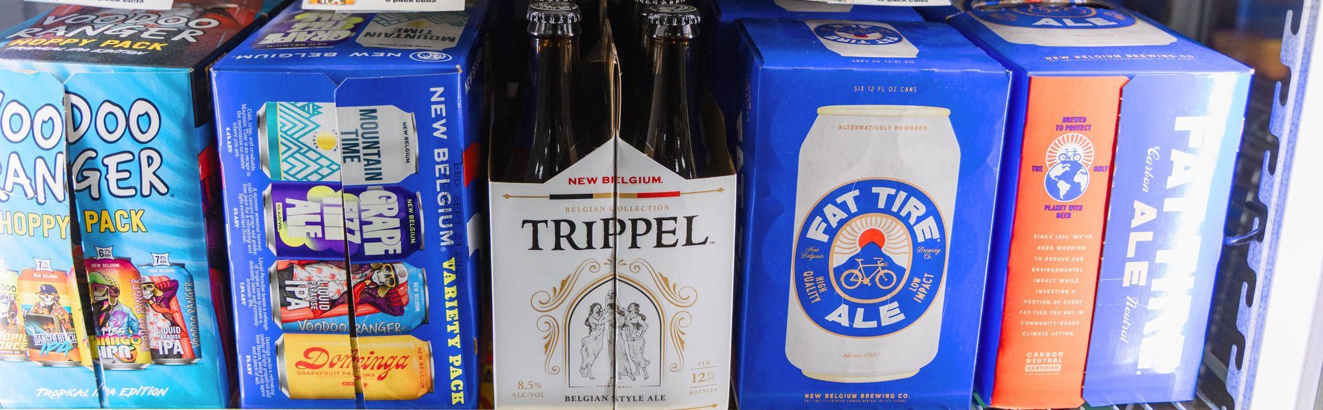 A shelf displaying various beer boxes, including