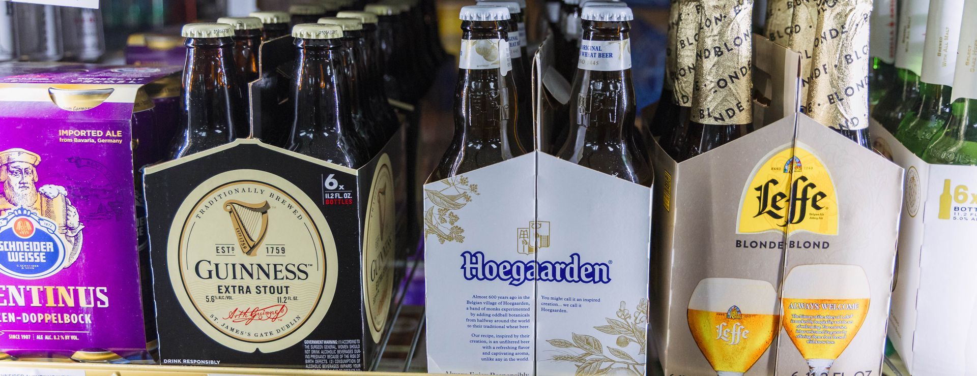 Various beer bottles in six-packs, including Guinness, Hoegaarden, and Leffe.