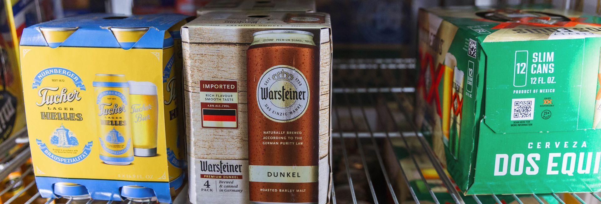 Beer boxes in a refrigerator, various brands and colors.