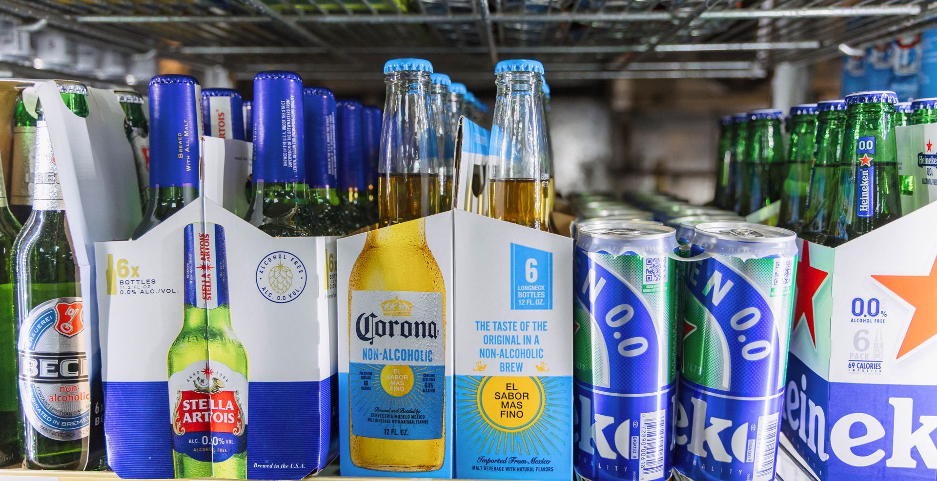 Beer in packaging on a store shelf; Corona, Heineken, and other brands visible.