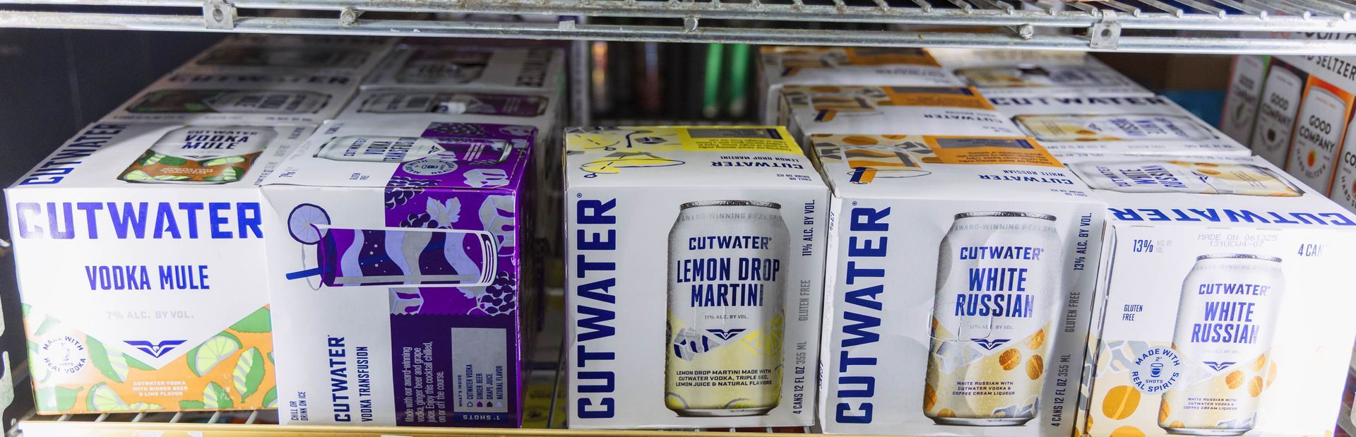 Canned cocktails on display in a refrigerator. Brands include Cutwater.