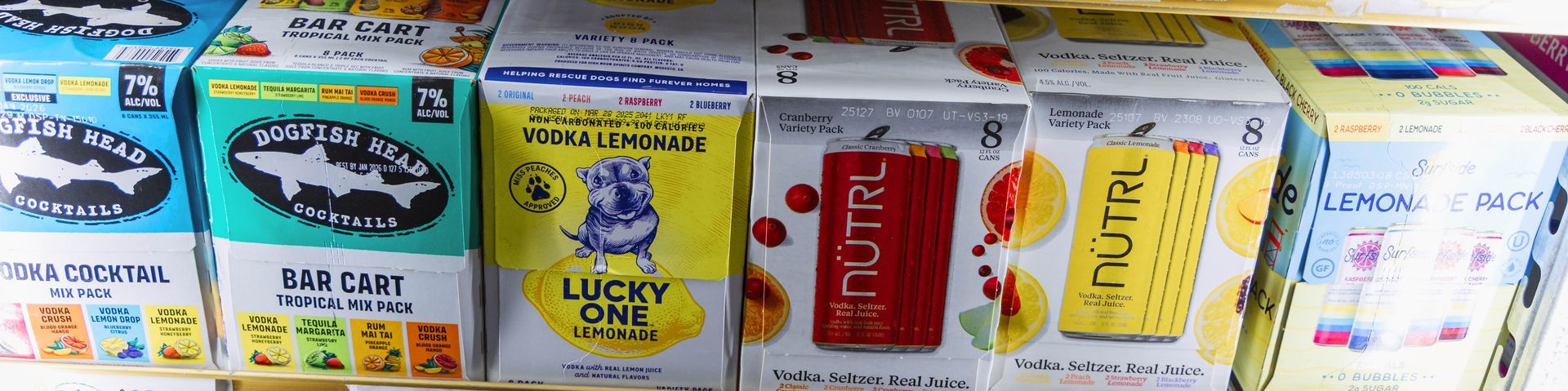 Boxes of various drinks, including fish, Lucky Day, and Nutri drinks, on a shelf.