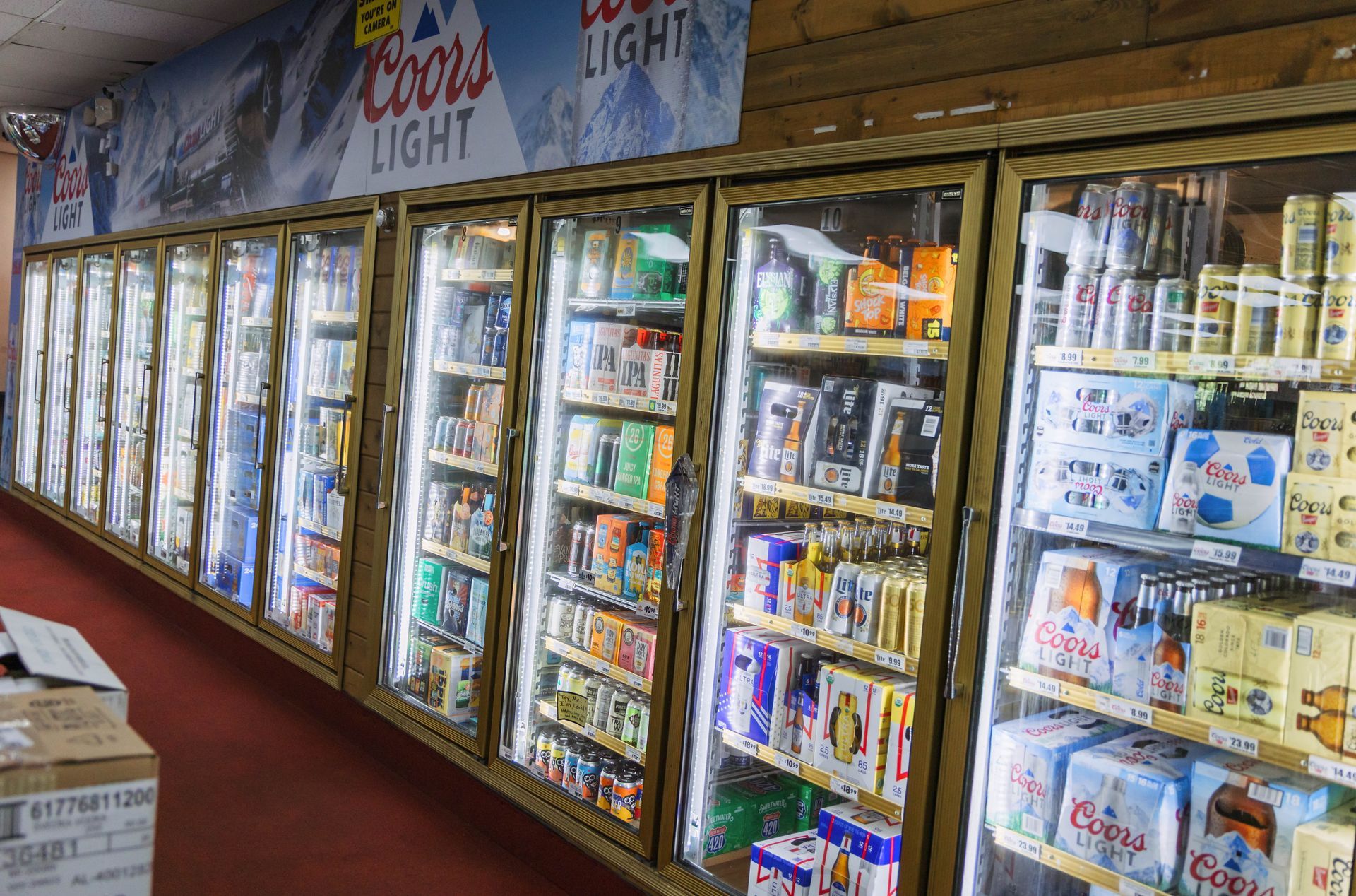 Cooler aisle in a store, filled with various beverages, including Coors Light.