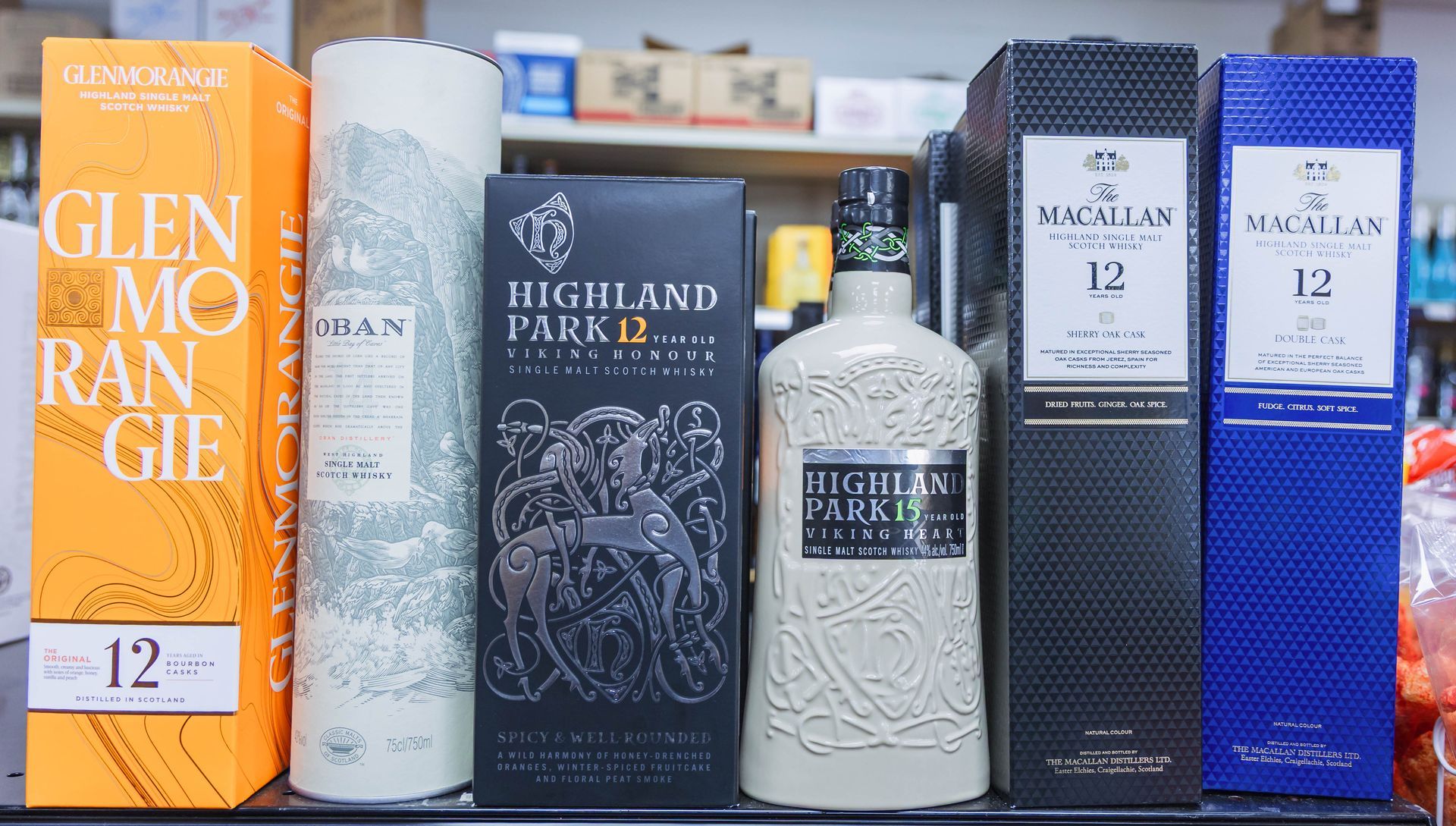 Bottles of various whisky brands: Glenmorangie, Macallan, and Highland Park, displayed in a store.