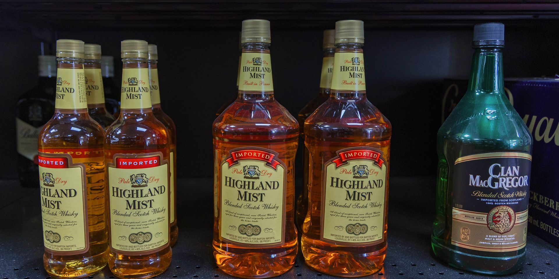 Bottles of Highland Mist and Clan McGregor liquor on a shelf, amber and green colors.