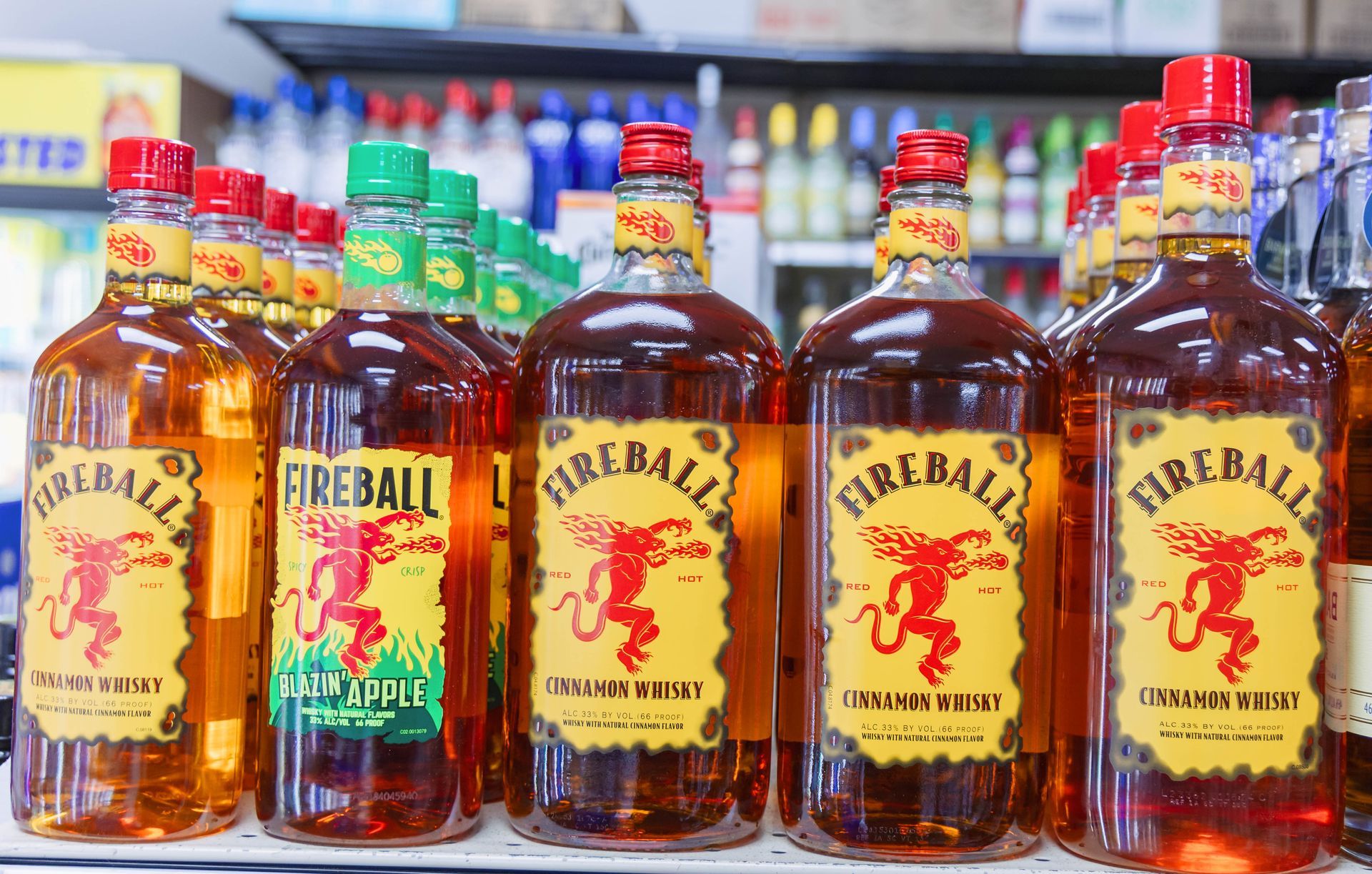 Bottles of Fireball cinnamon whiskey lined up on a shelf in a store.