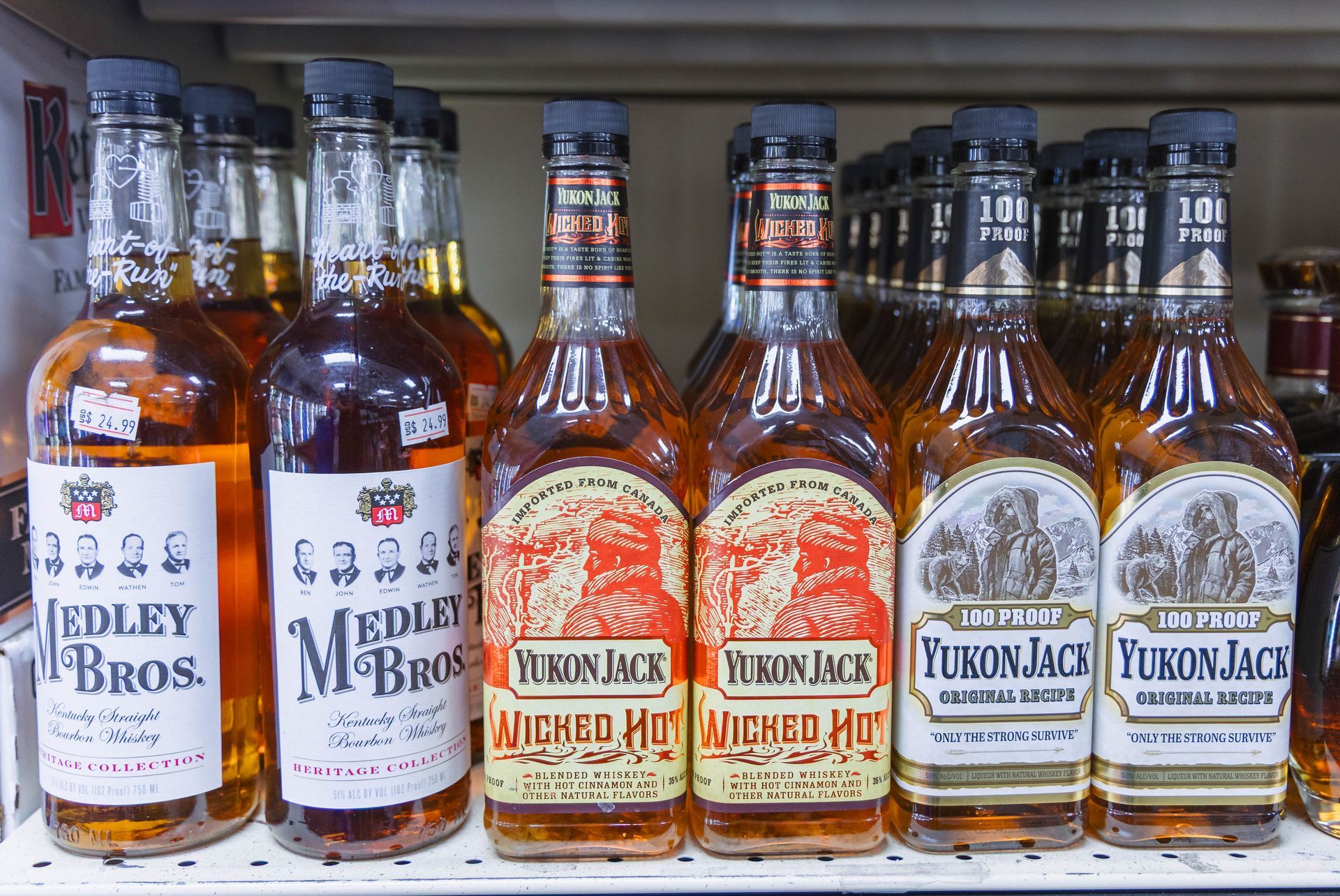 Bottles of liquor on a shelf. Brands include Medley Bros. and Yukon Jack in a liquor store.
