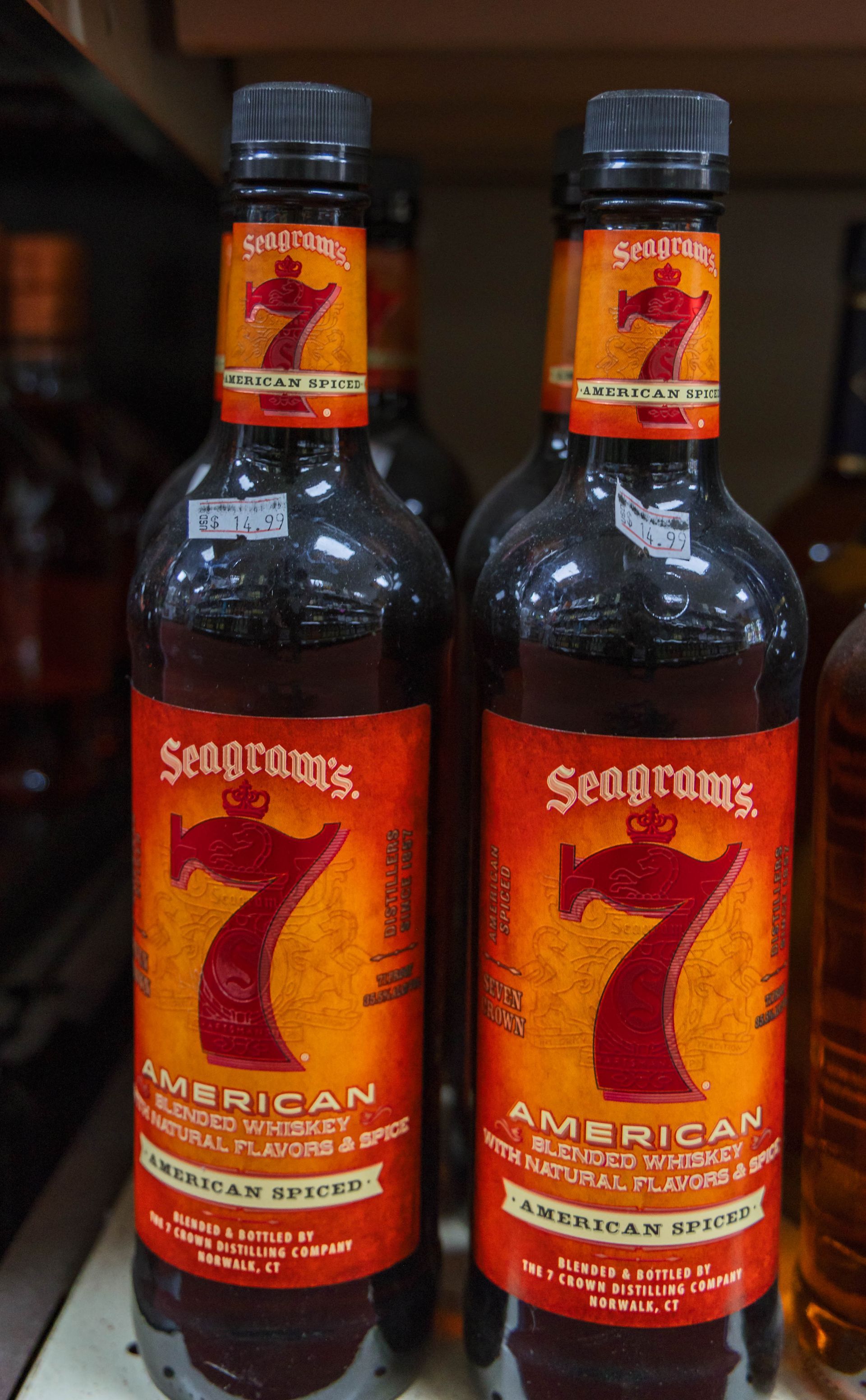 Two bottles of Seagram's 7 American Spiced whiskey, red and orange labels.