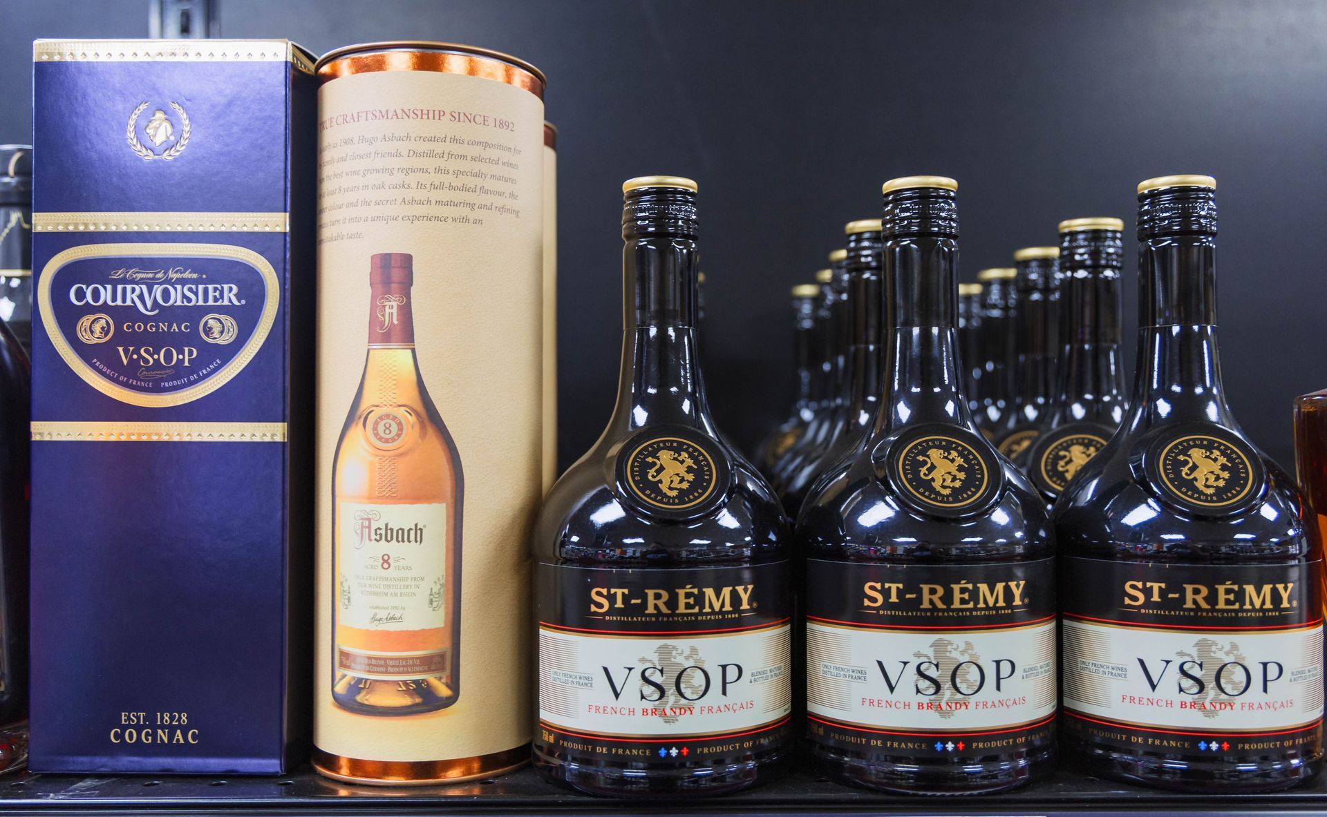 Bottles of St-Remy VSOP brandy and a Courvoisier box on a shelf.
