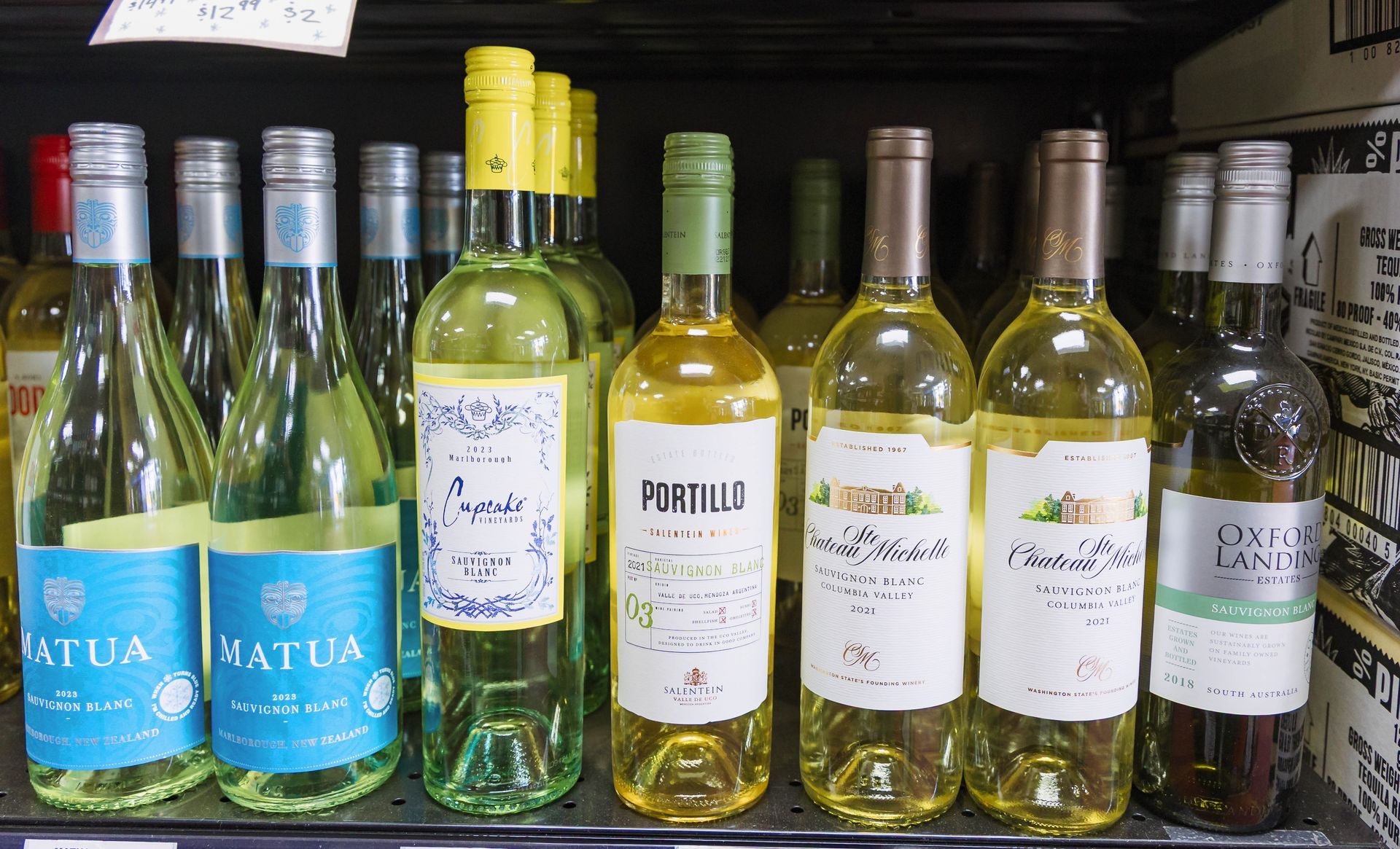 Shelves stocked with bottles of white wine.