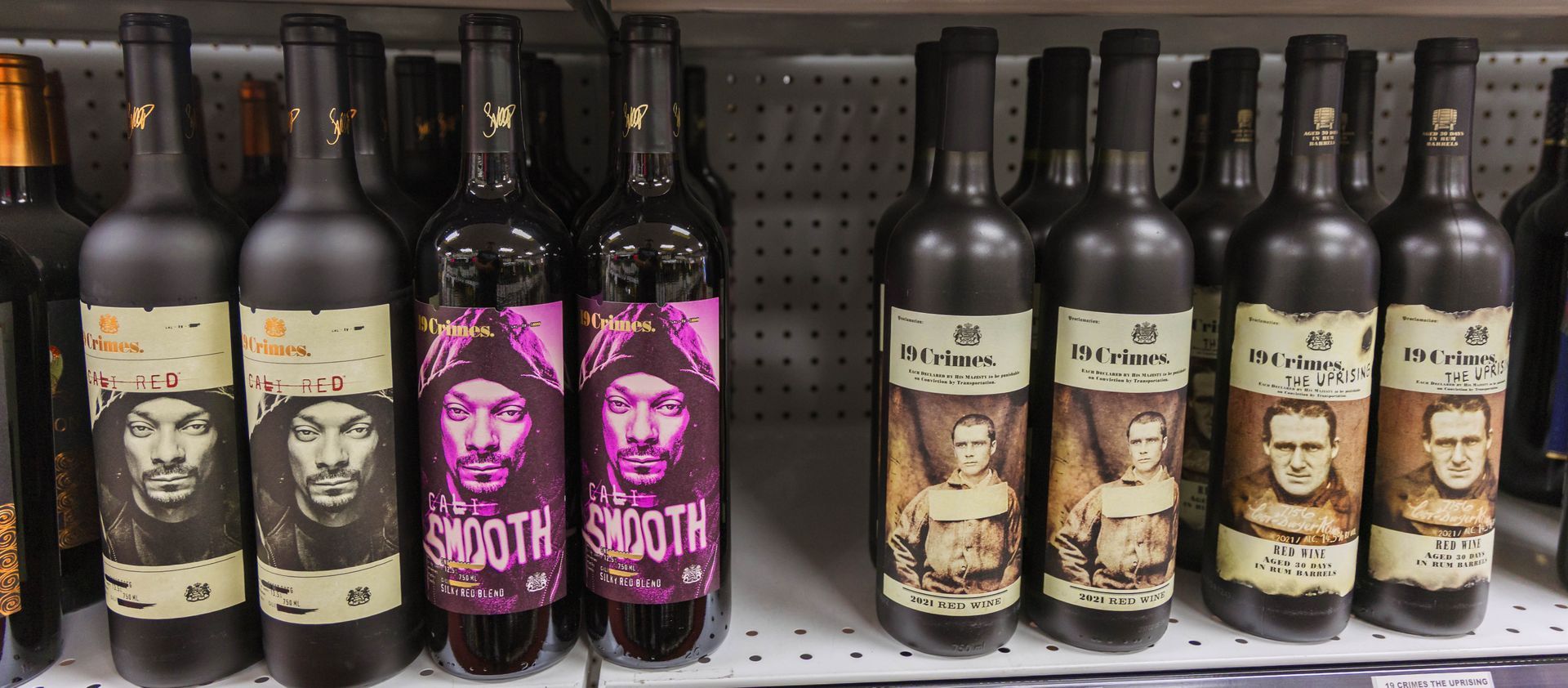 Bottles of wine on shelves with faces on the labels.