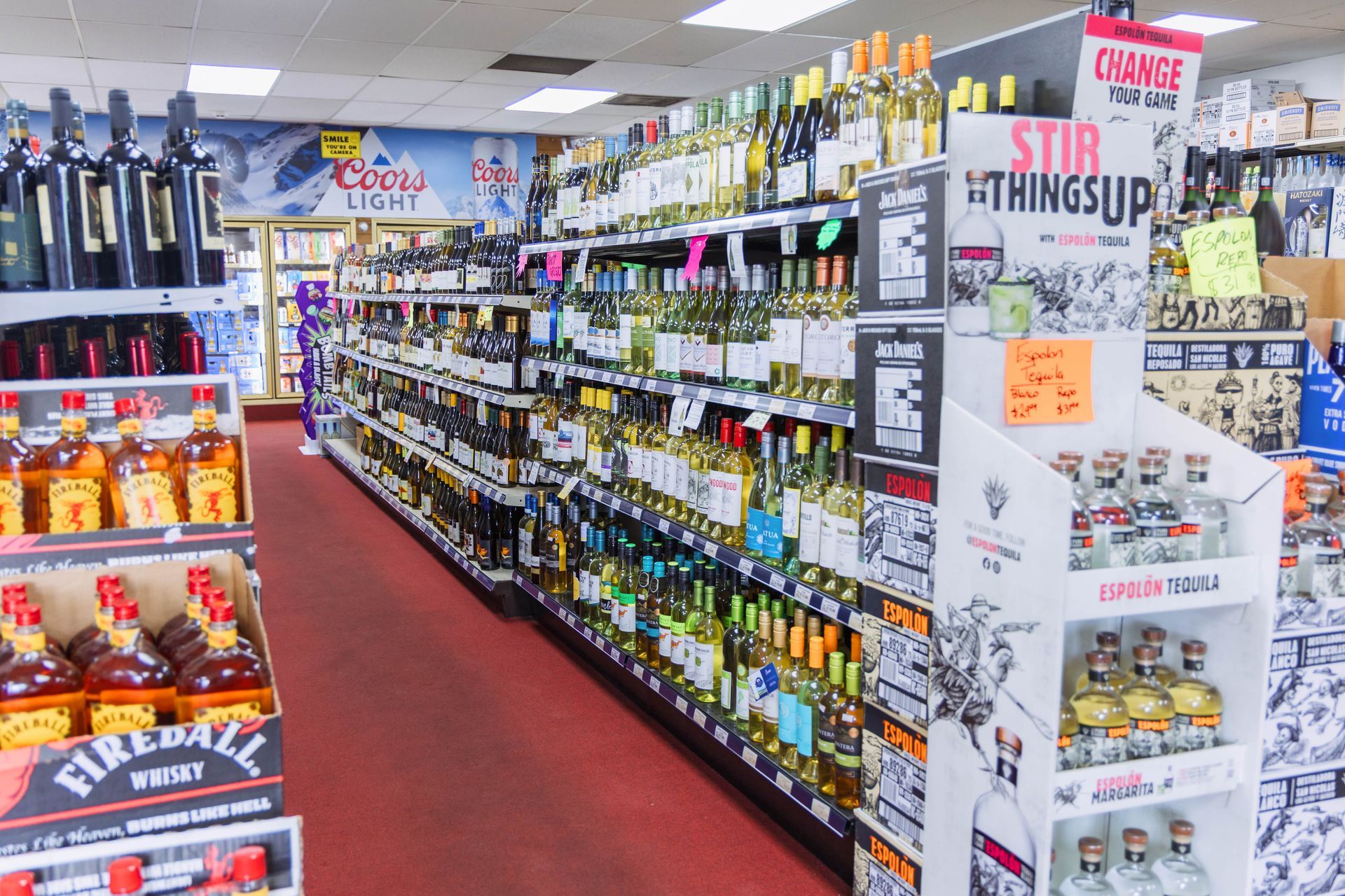 Liquor store aisle with various bottles of wine, liquor, and a Fireball display.