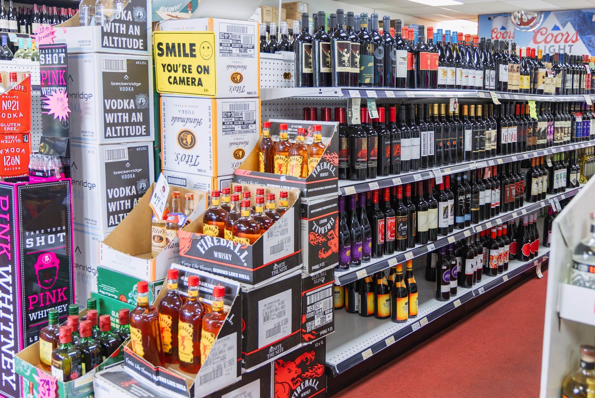 Liquor store interior with shelves of alcohol bottles, including wine, whiskey, and vodka.