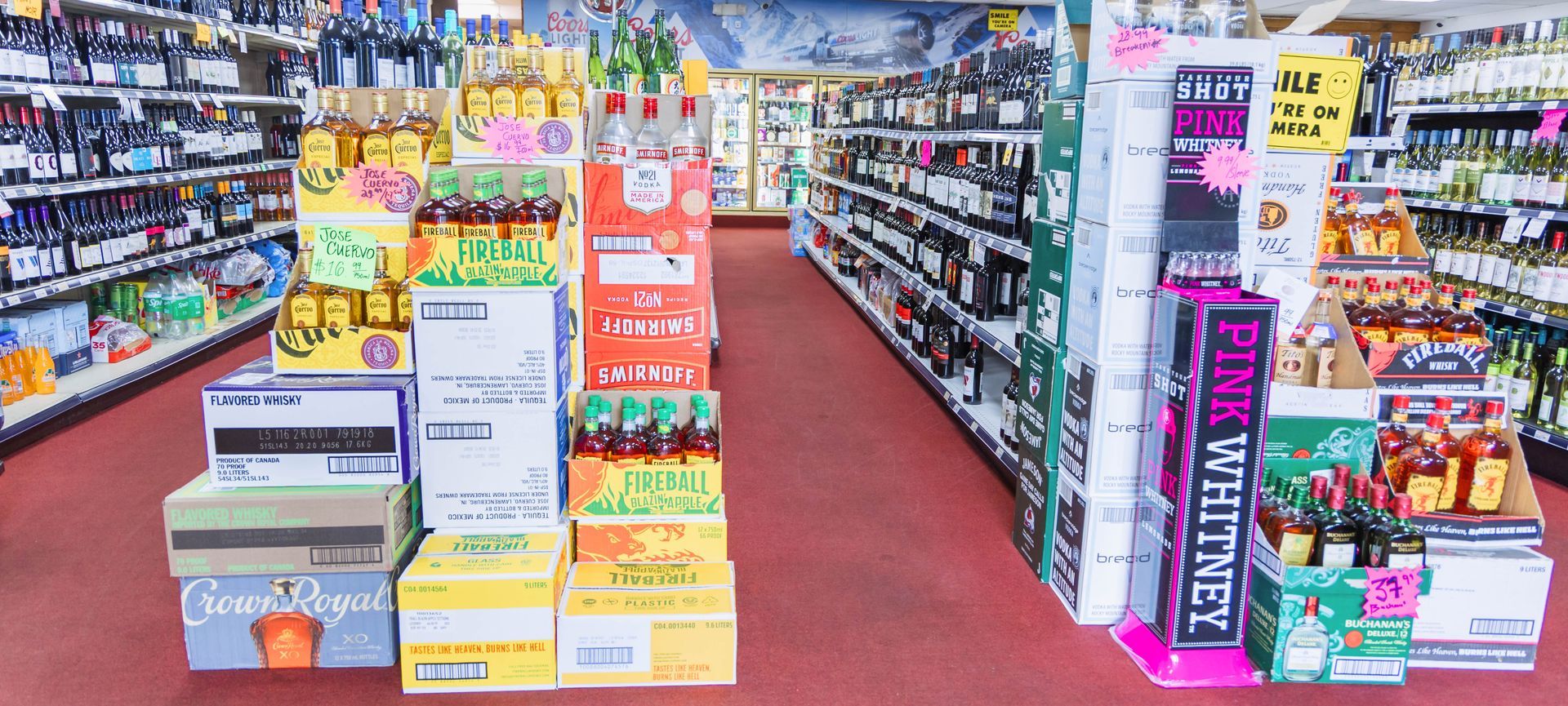 Inside a liquor store, various displays of beverages are visible.