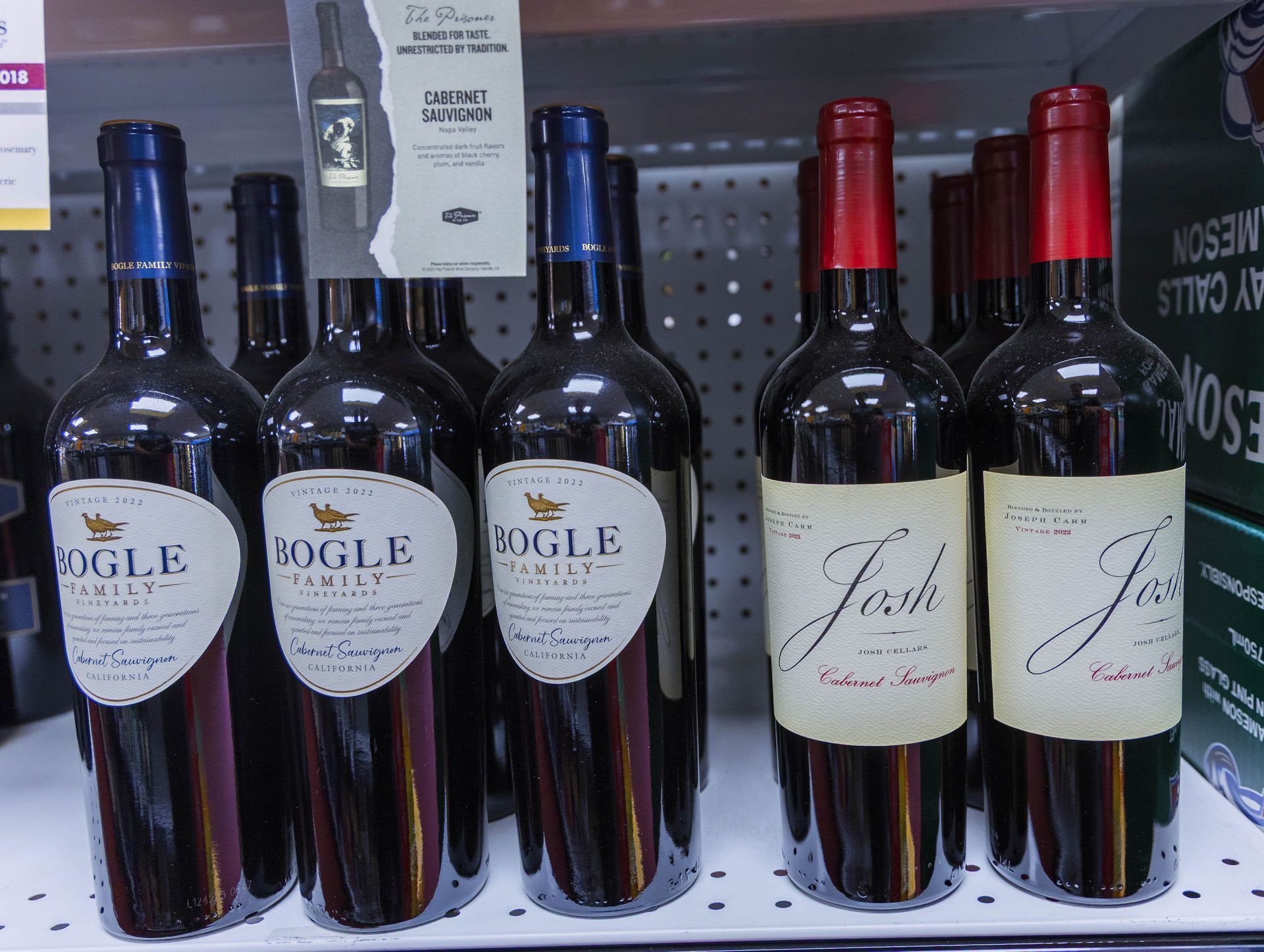 Wine bottles on a shelf: Bogle and Josh labels, blue and red caps.