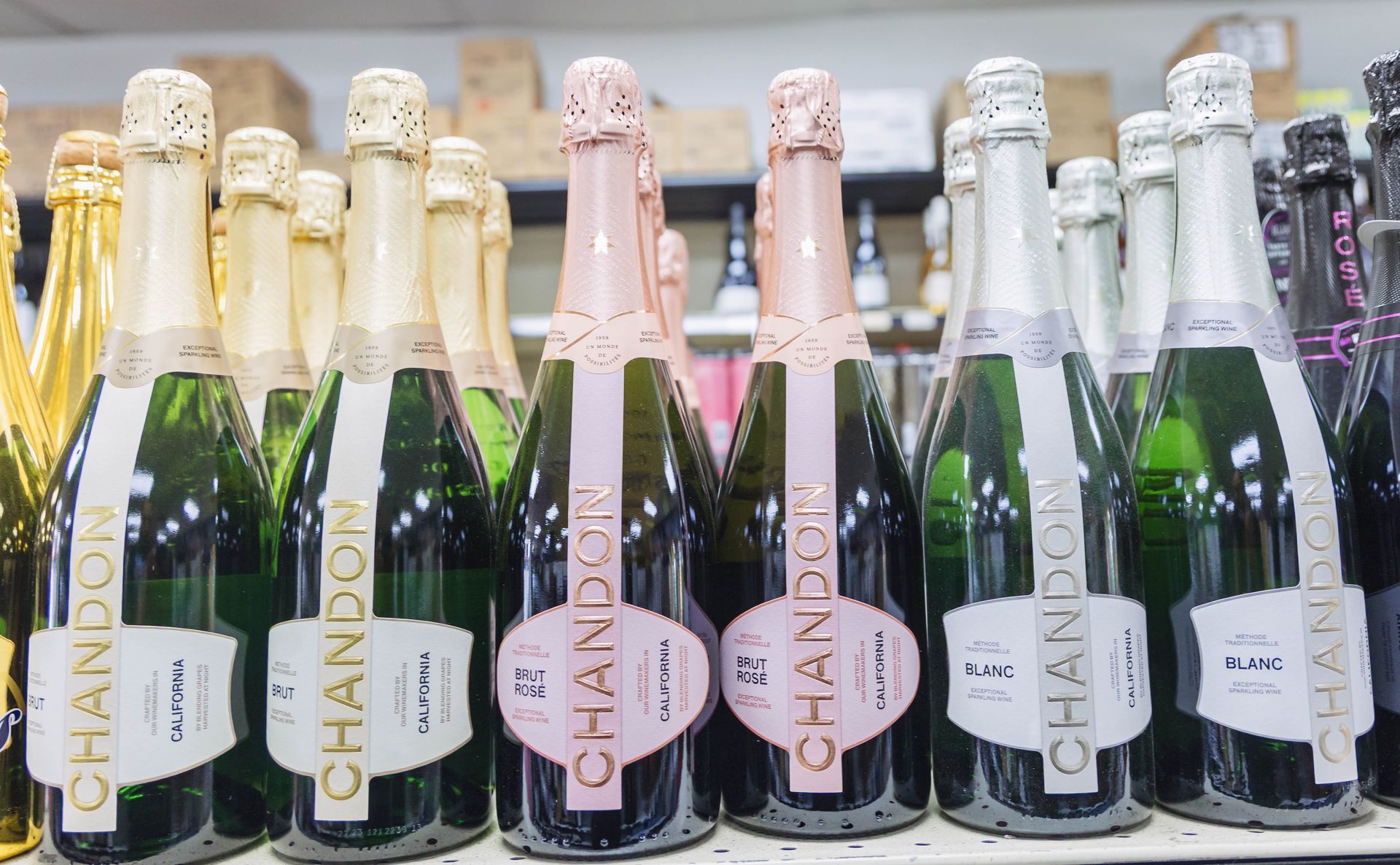 Bottles of Chandon sparkling wine on a shelf, with gold, pink, and silver labels.