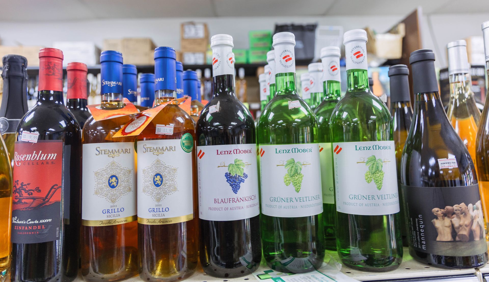 Bottles of wine on a shelf, various colors and labels.