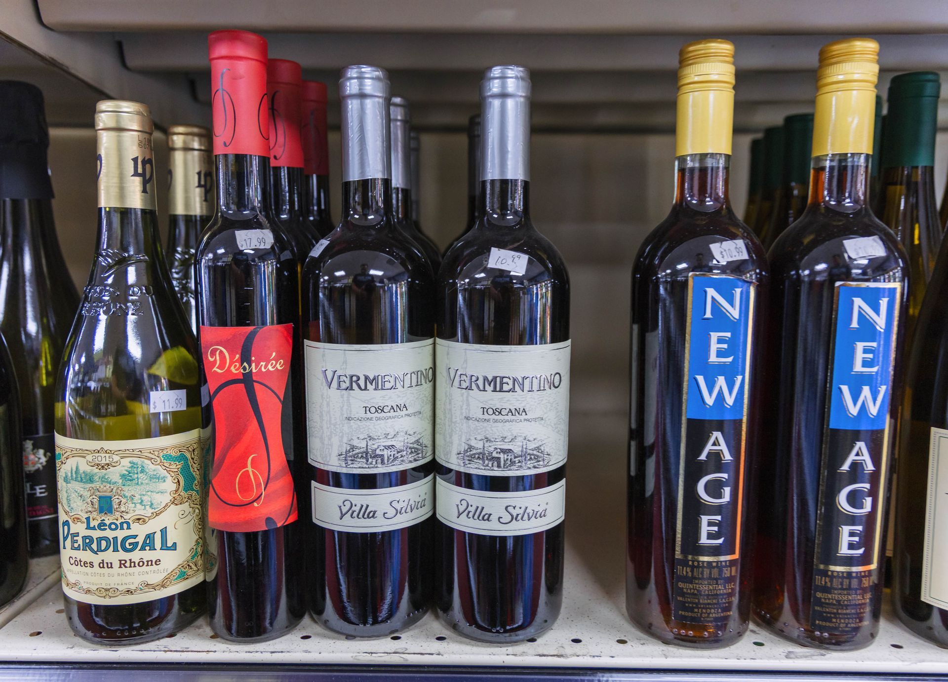 Bottles of wine on a shelf, featuring labels like
