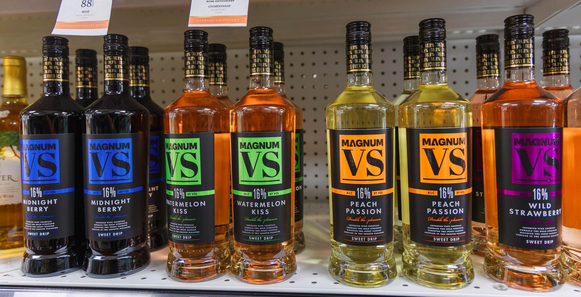 Bottles of alcohol with colorful labels on a shelf in a store.