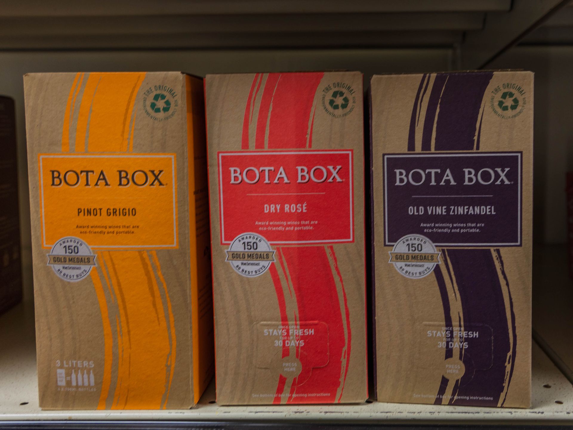 Three boxes of Bota Box wine: Pinot Grigio, Dry Rosé, and Old Vine Zinfandel. Brown boxes with colorful labels.