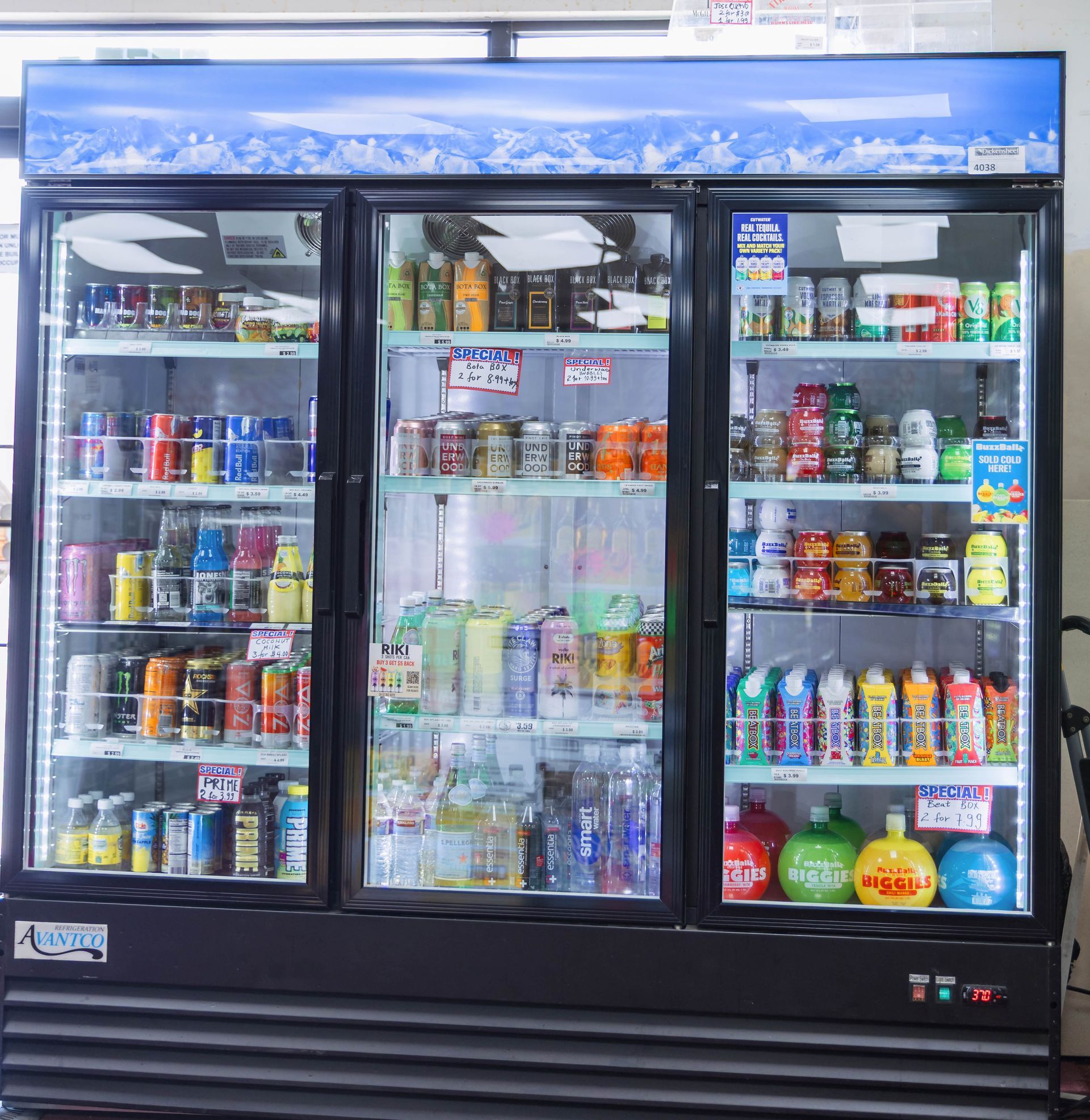 A triple-door refrigerator stocked with various colorful beverages in a convenience store.