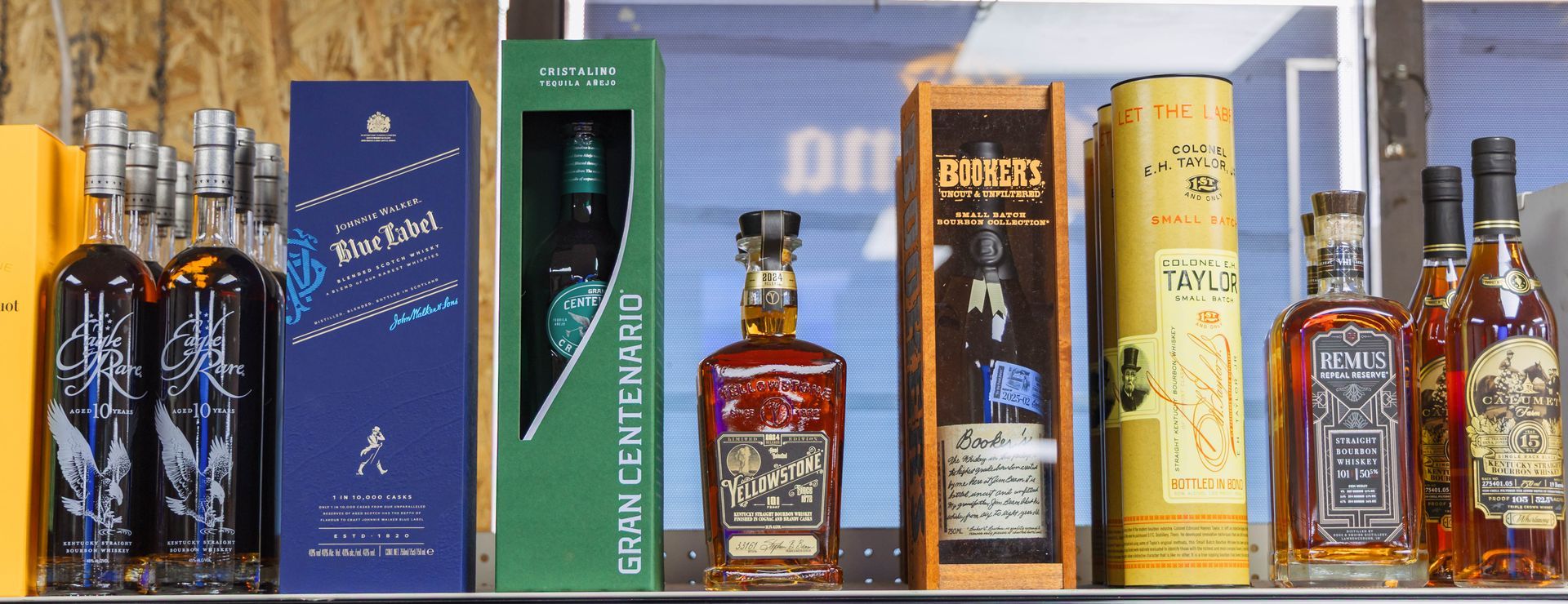 Bottles of liquor on a shelf, in various shapes, sizes and colors.