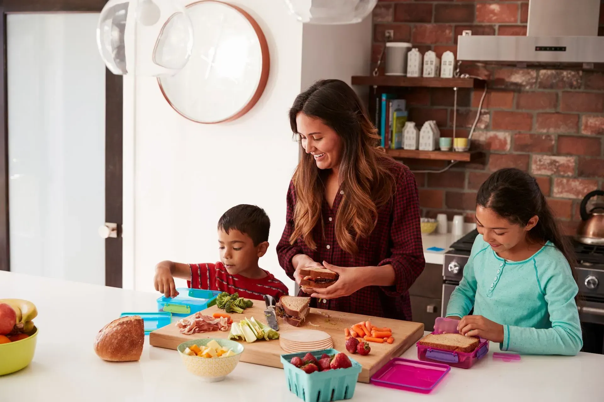 A mother with her two children are preparing food in a kitchen.