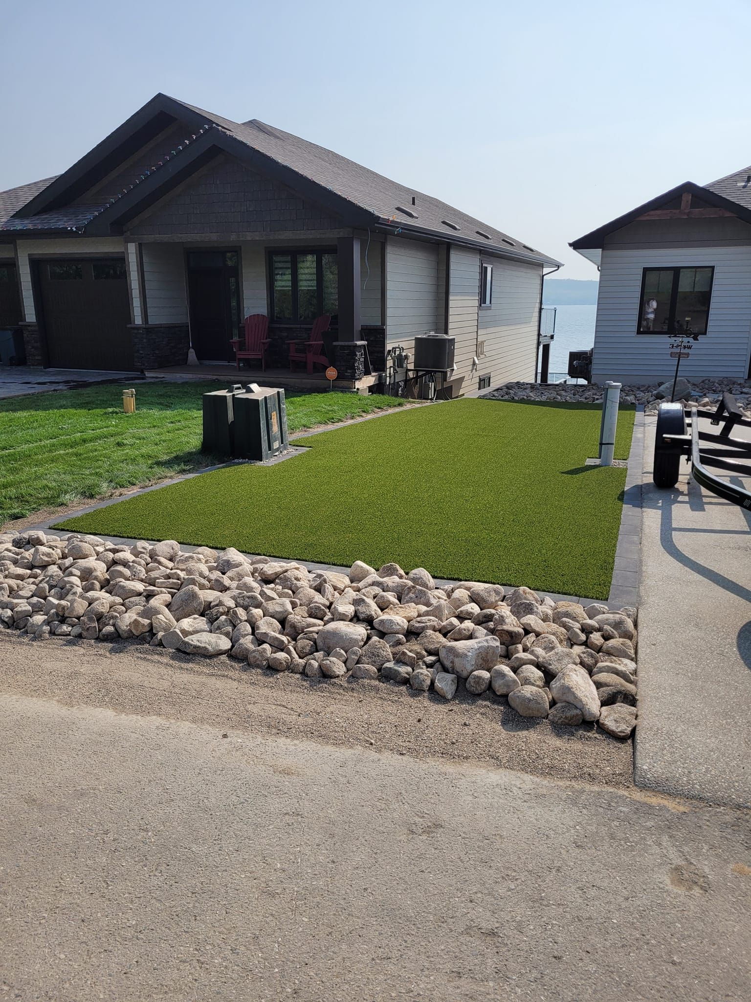 A man is mowing a lush green lawn in front of a house.