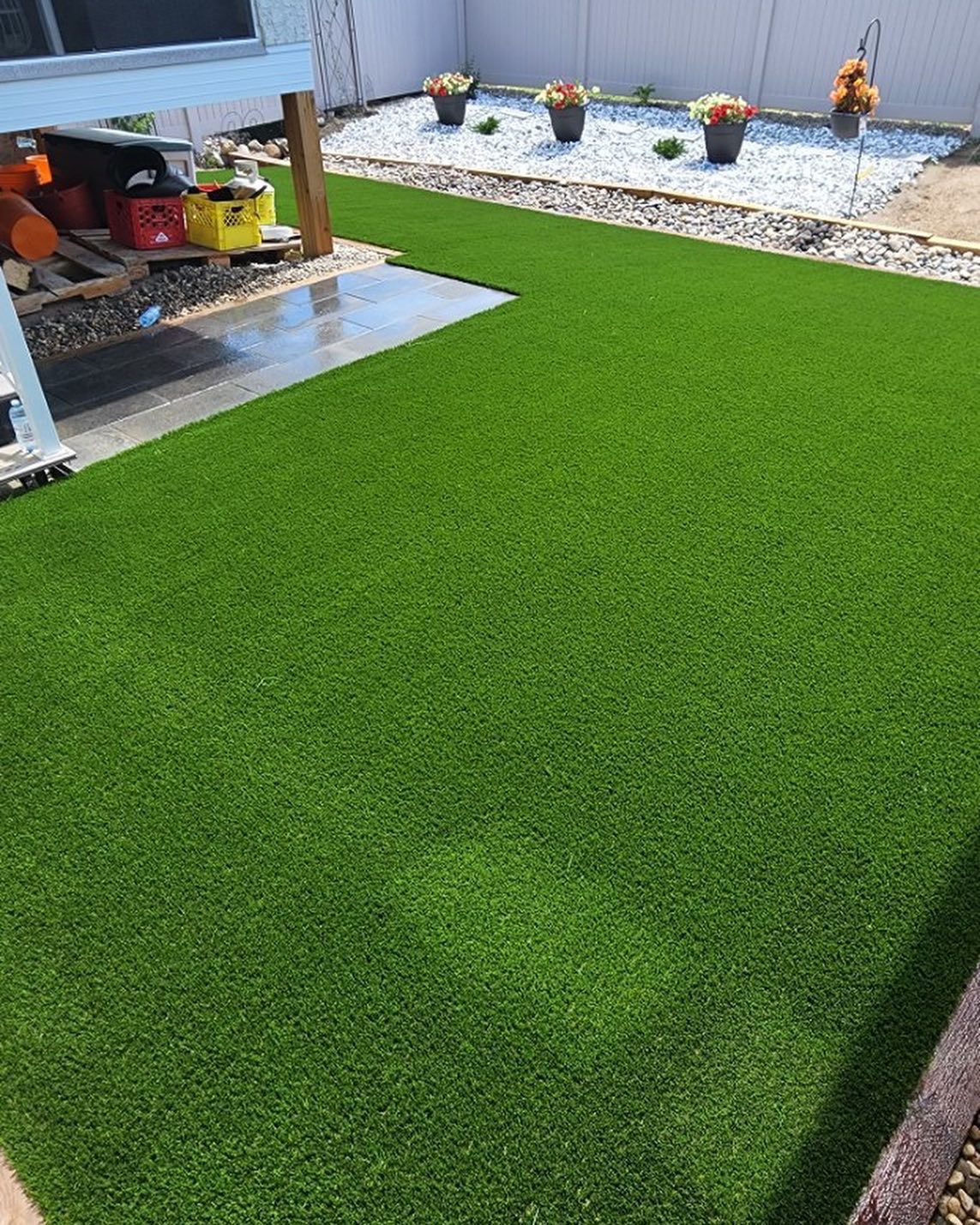 A backyard with a lot of green grass and flowers.