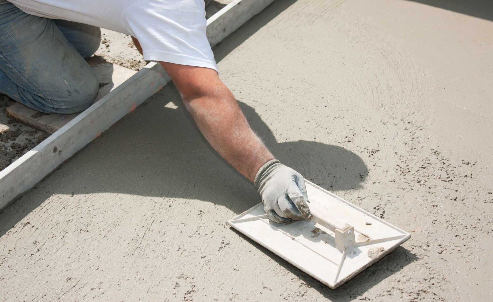 Concrete service contractor in Knoxville, TN applying cement with a trowel.