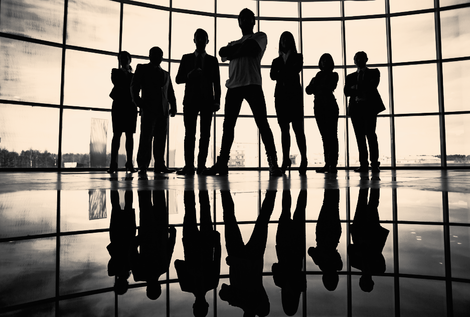 A group of people are standing in front of a large window.