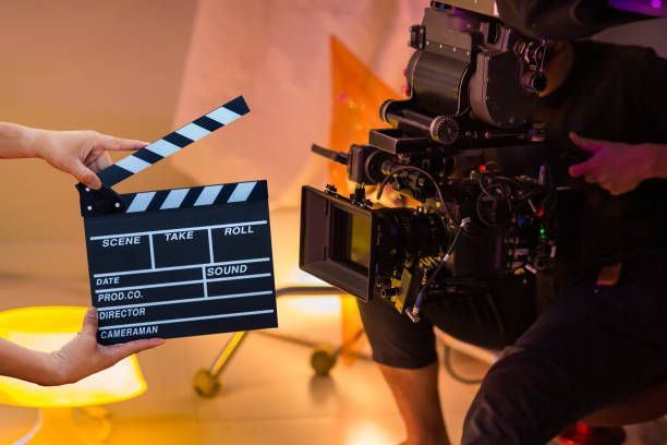 A person is holding a clapper board in front of a camera.